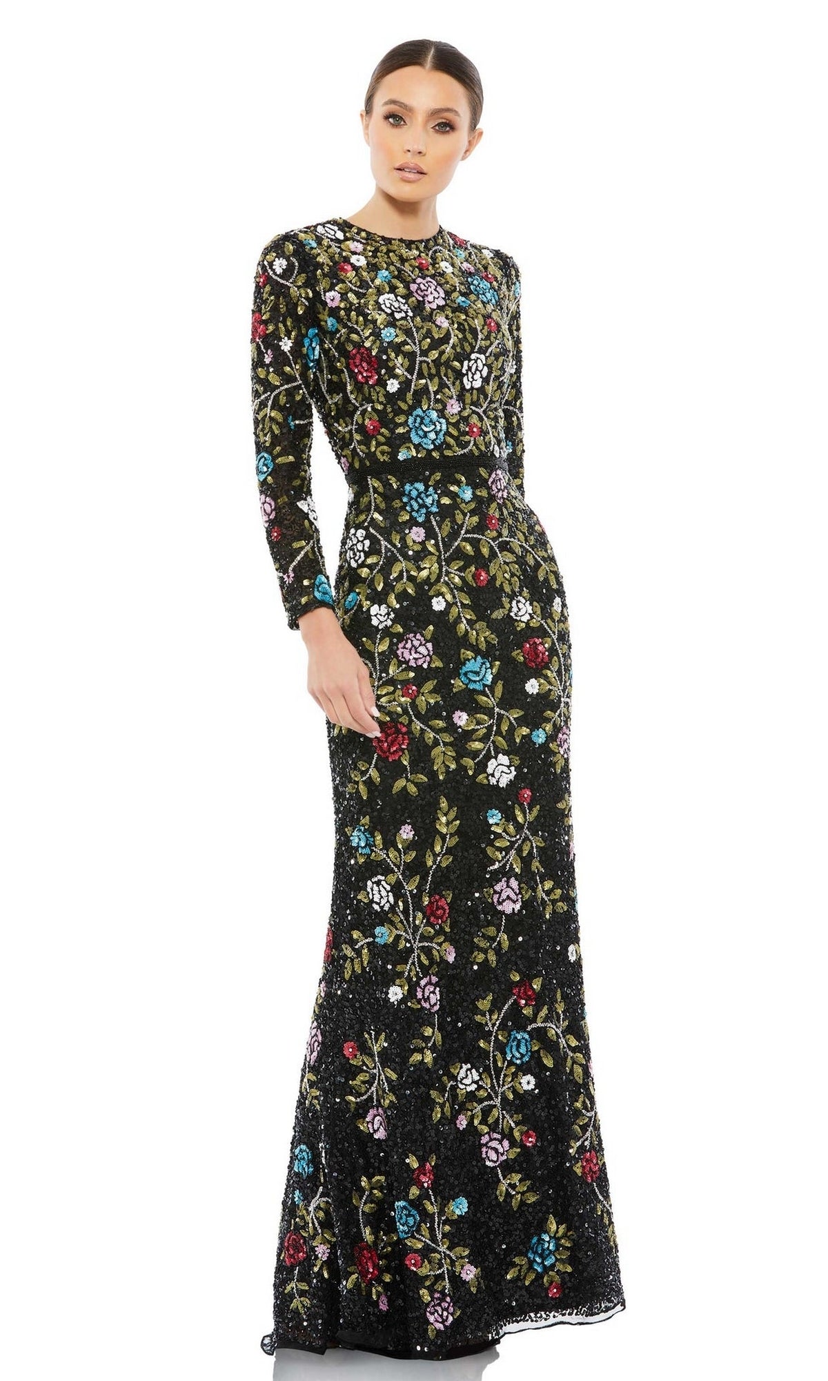 A woman wears the Mac Duggal 5556 Long Black Print Formal Dress with colorful embroidery and long sleeves, standing against a plain white background.