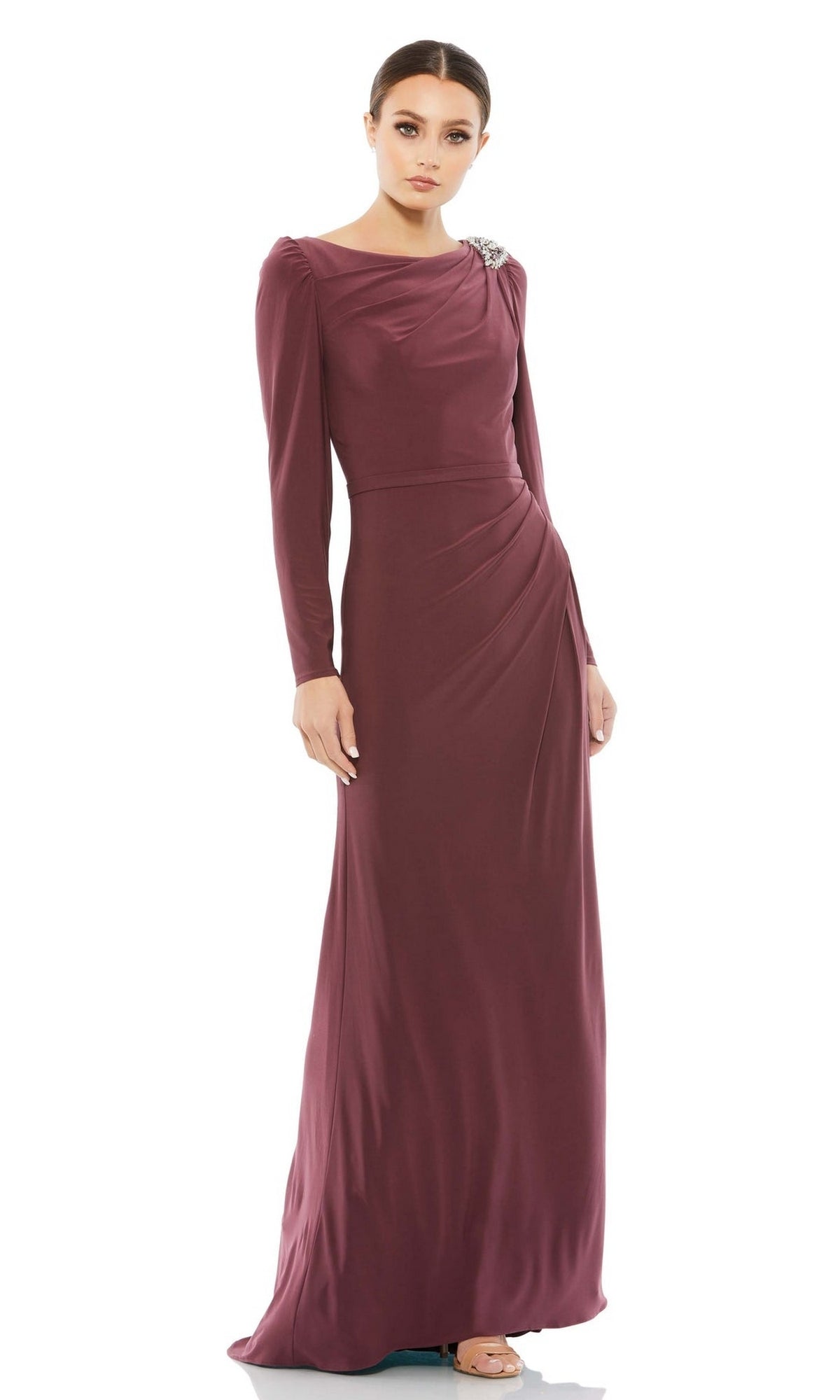A woman models the Long Formal Dress 55695 by Mac Duggal—a long-sleeved, floor-length mauve gown with gathered details and shoulder embellishment—standing against a white background.