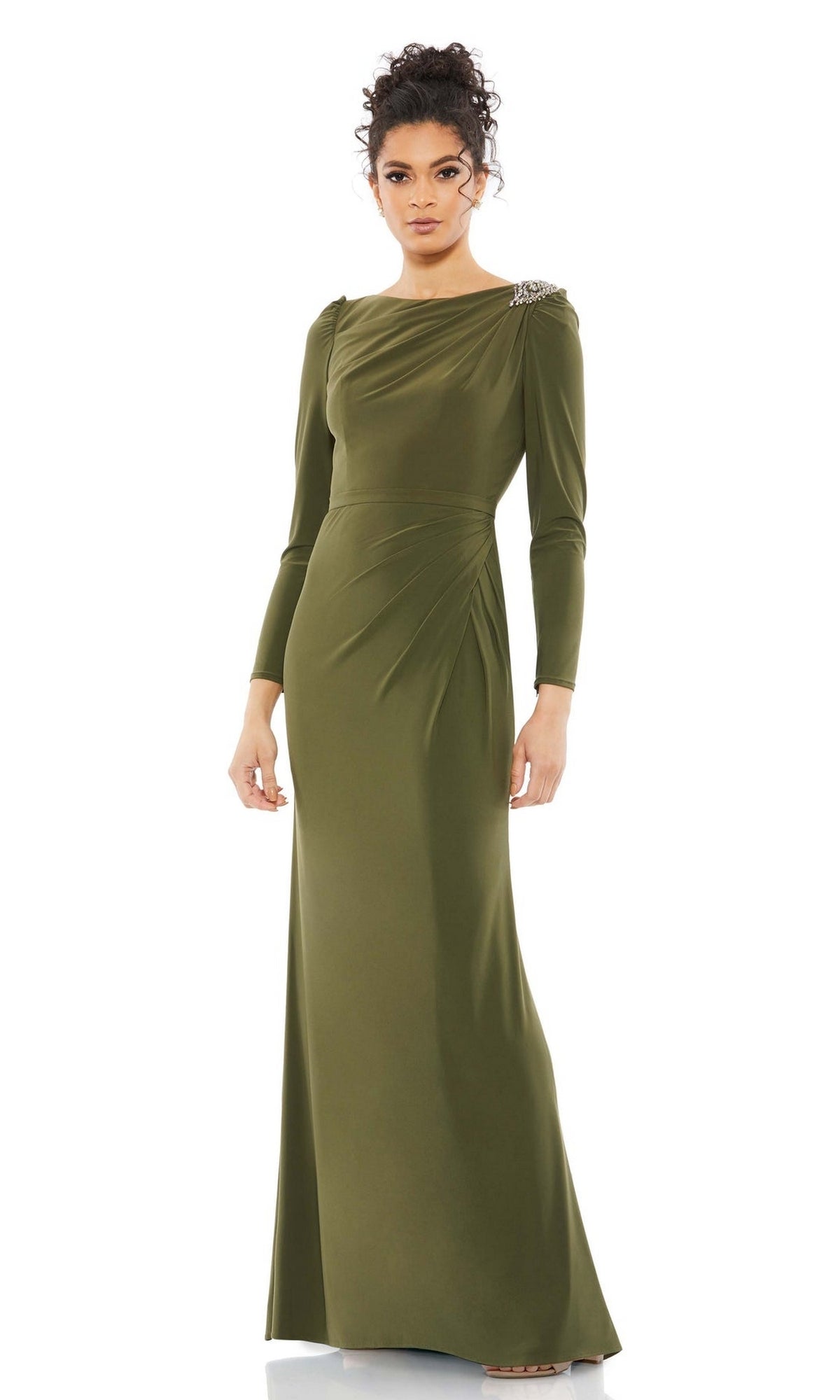 A woman models the Mac Duggal Long Formal Dress 55695 in olive green featuring a high neck, draped design, and shoulder embellishment, posed against a white background.
