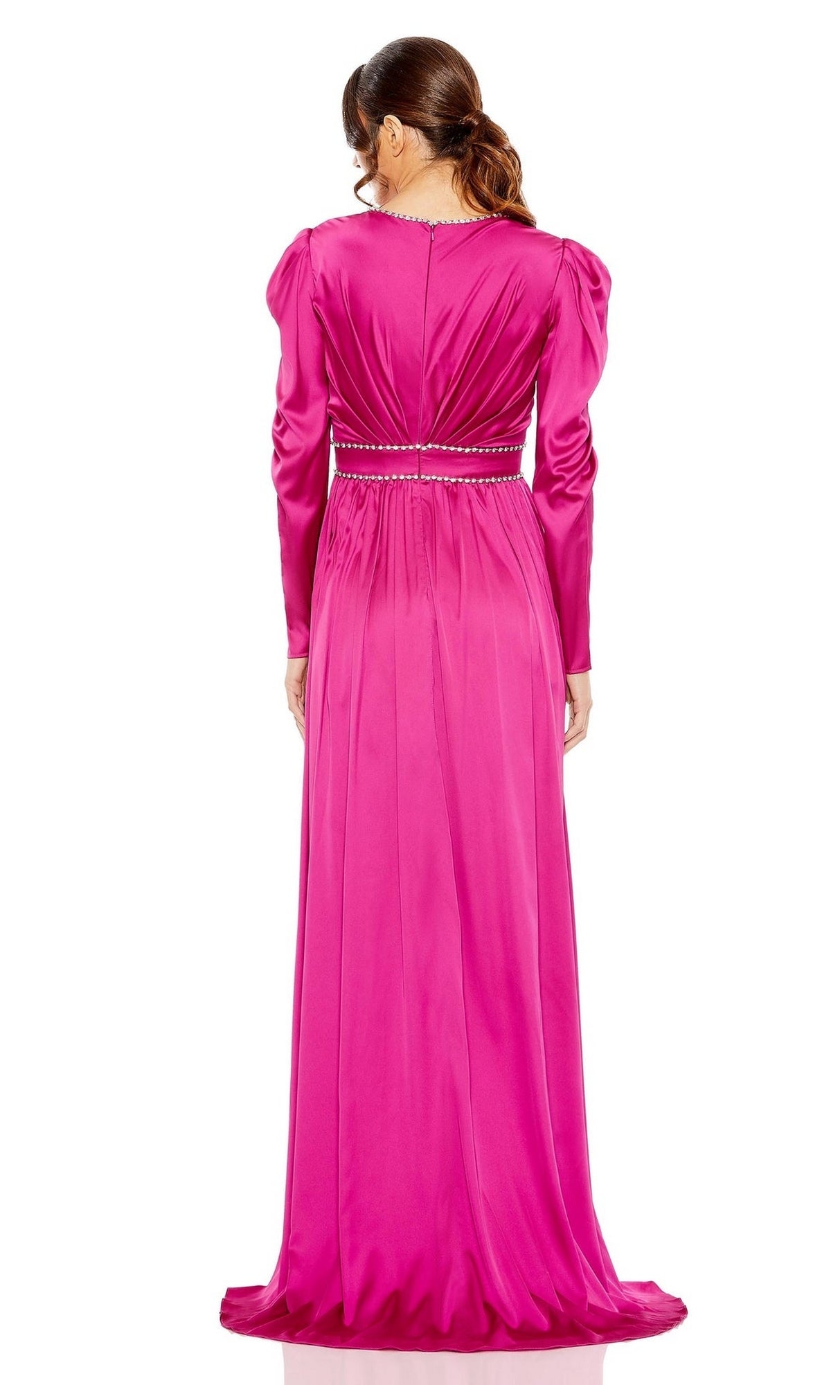 A woman stands facing away, wearing the Long Formal Dress 55702 by Mac Duggal—a bright pink, floor-length gown with long sleeves, a gathered waist, beaded belt detail, and elegant rhinestone trim.