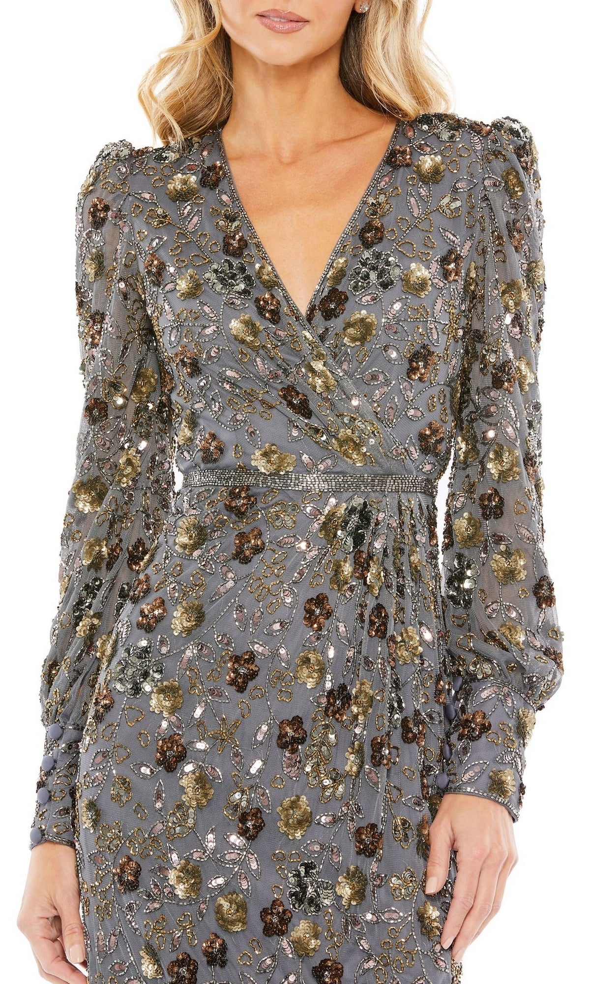 A woman wears the Short Semi-Formal Dress 5571 by Mac Duggal, a charcoal beaded dress with long sleeves, V-neck, and gold, silver, and bronze floral embroidery plus sequins.