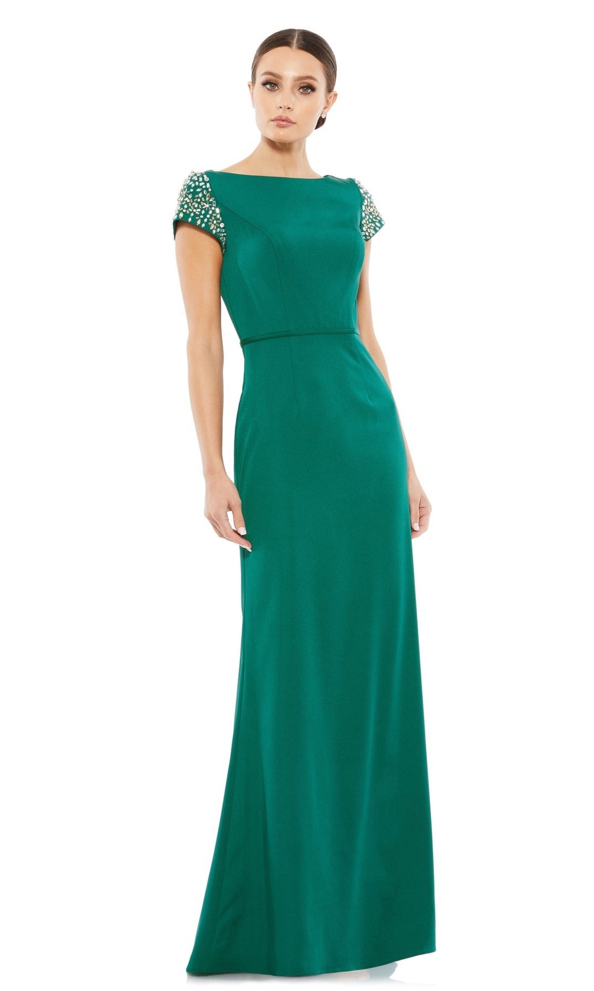A woman in the Long Formal Dress 55718 by Mac Duggal, an emerald green, floor-length fitted gown with short beaded sleeves, stands against a plain white background.