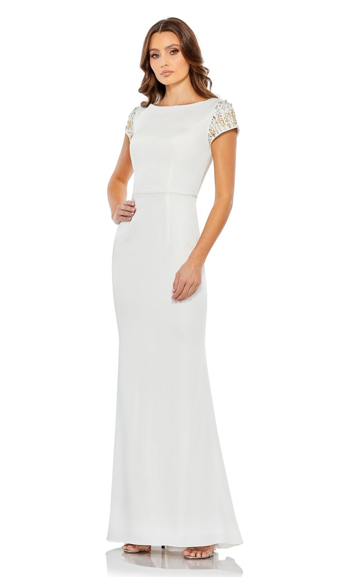 A woman stands against a plain white background wearing the Long Formal Dress 55718 by Mac Duggal, a floor-length column gown featuring a high neck and short, beaded sleeves.