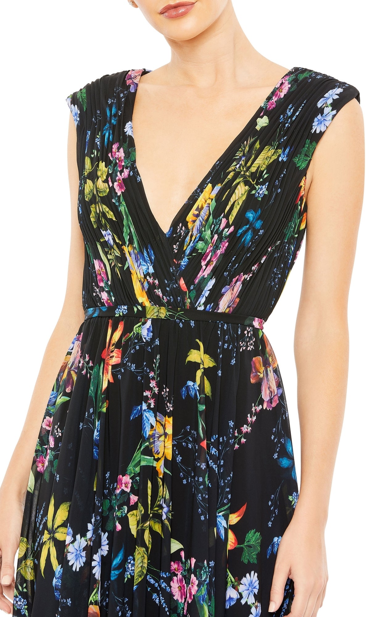 A person is wearing the Mac Duggal 55829 Long Floral-Print Formal Dress, a sleeveless black gown with a deep V-neckline and vibrant floral print.