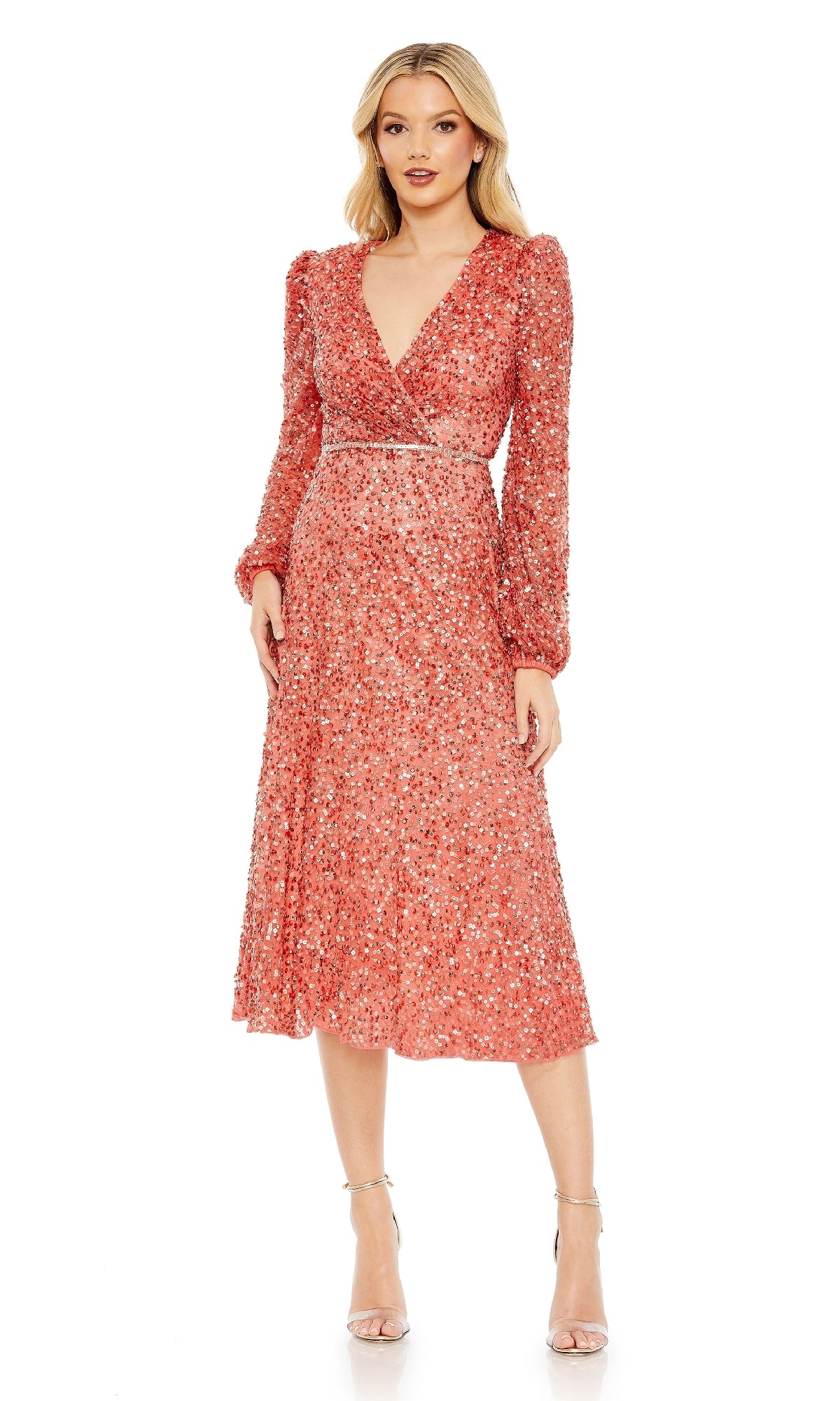 A woman models the Mac Duggal 5588 Coral Midi Wedding Guest Dress, featuring long sleeves, sequins, and a V-neckline, standing forward with hands by her sides and styled with nude heels.