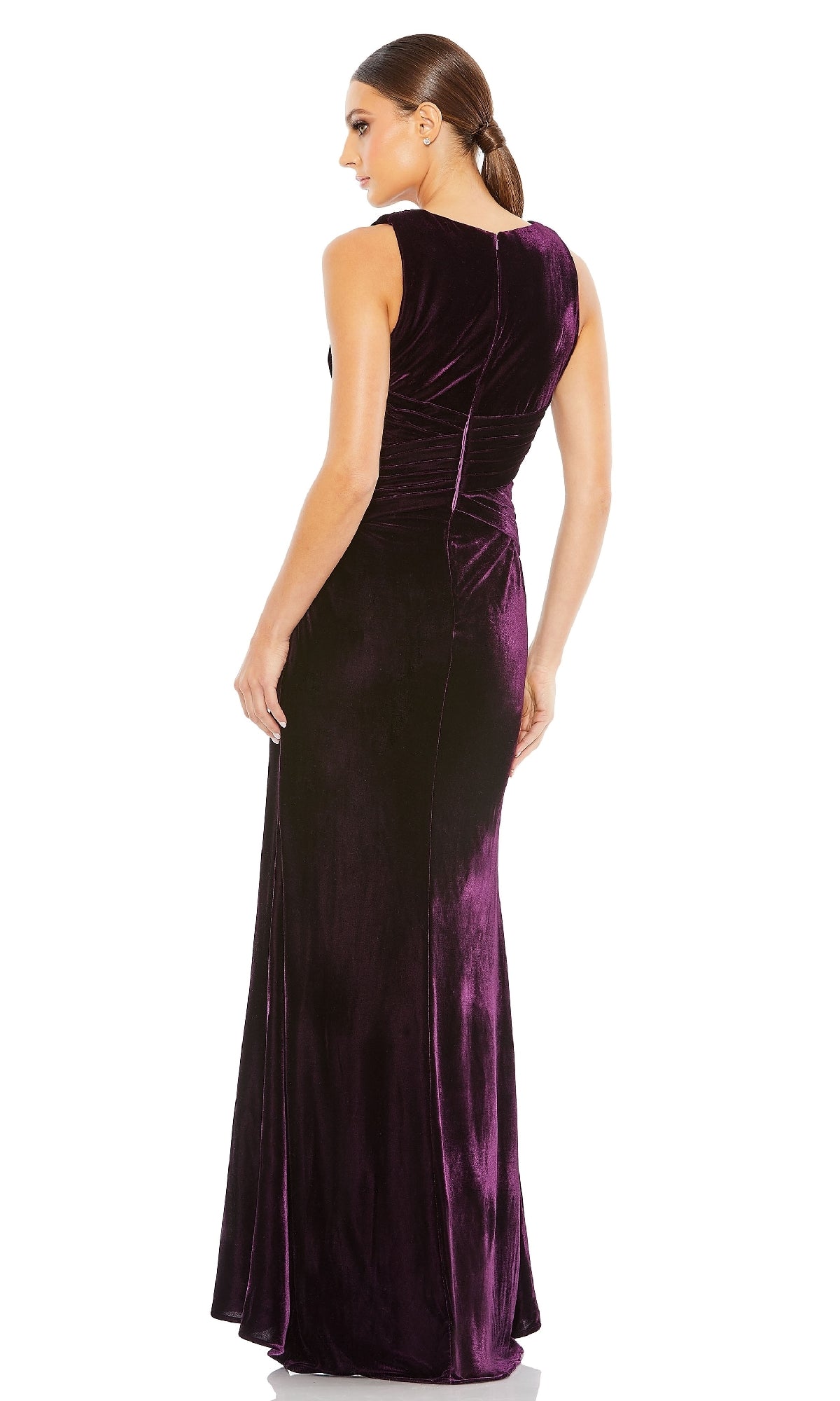 A woman with her hair in a low ponytail stands with her back to the camera, wearing the Mac Duggal 55957 Sleeveless Velvet Formal Gown, a floor-length dress in dark purple.