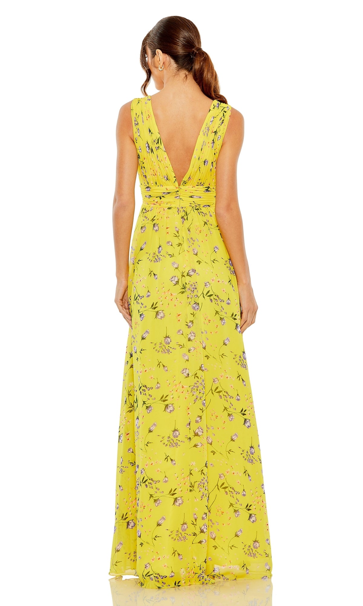 A woman stands facing away in the Long Formal Dress 56011 by Mac Duggal, a yellow floral gown with an a-line silhouette, deep V-back, and v-neckline.