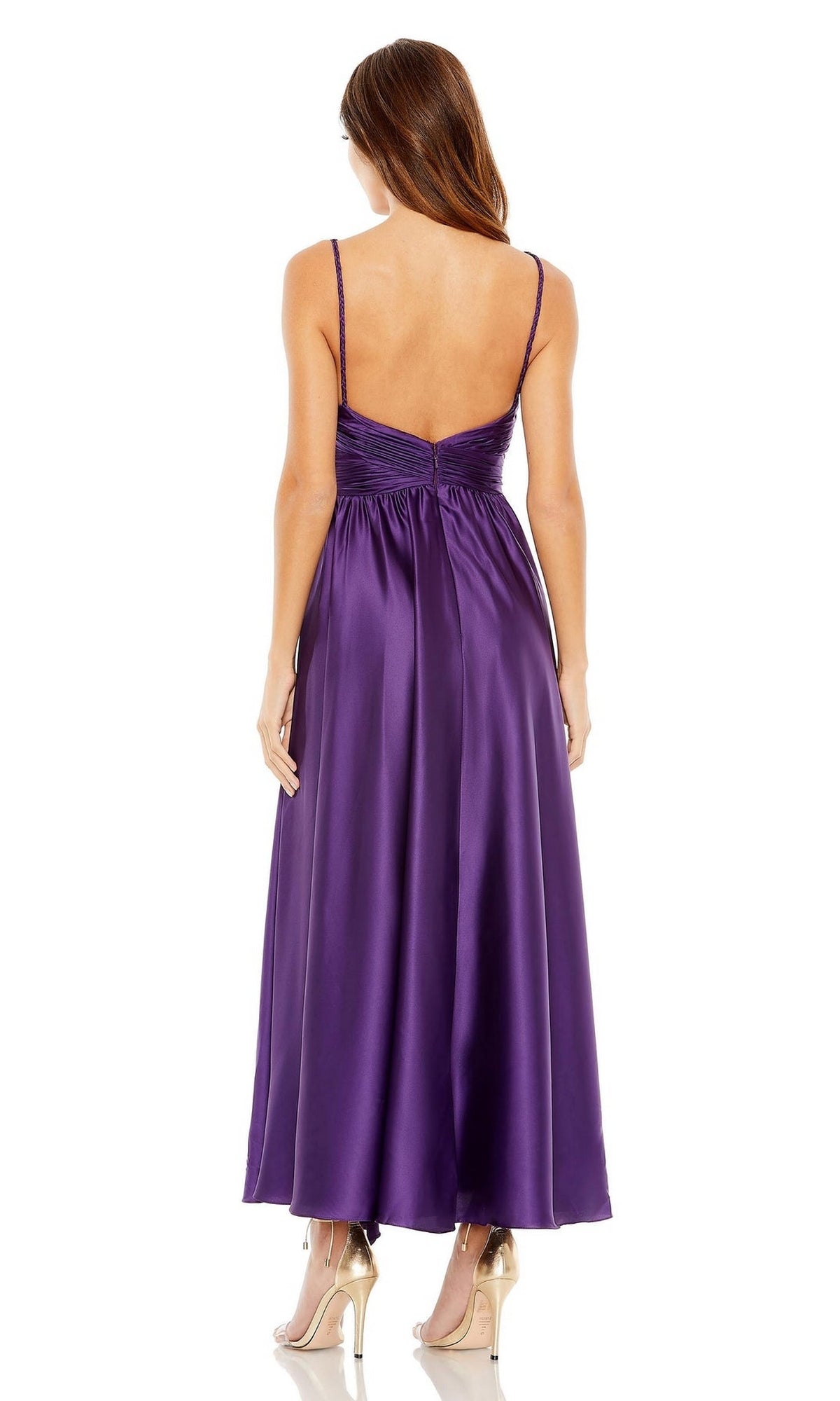 A woman faces away, wearing the Mac Duggal 56035 purple midi wedding-guest dress with a sleeveless design, V-back, and ankle-length hem, styled with beige high heels.