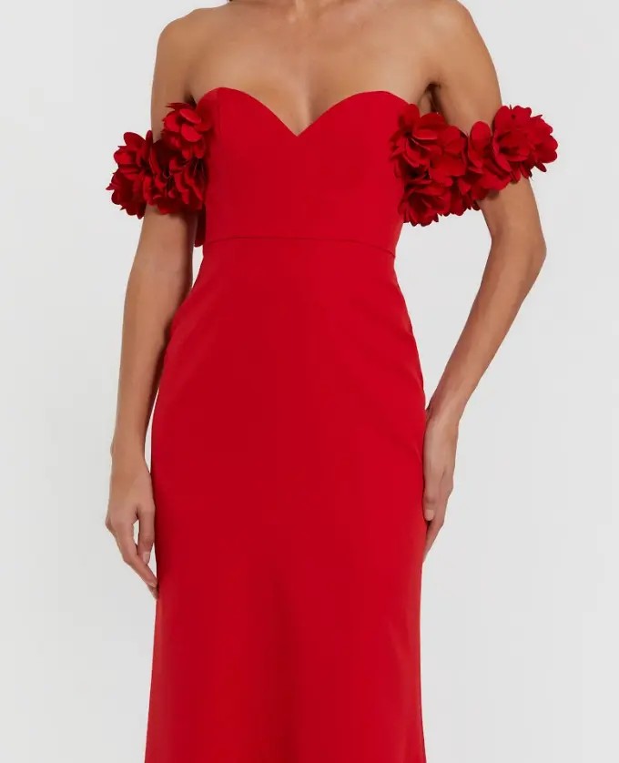 A woman wears the Mac Duggal 56131 Floral-Straps Long Formal Dress—a fitted red gown with a sweetheart neckline and floral strap details.