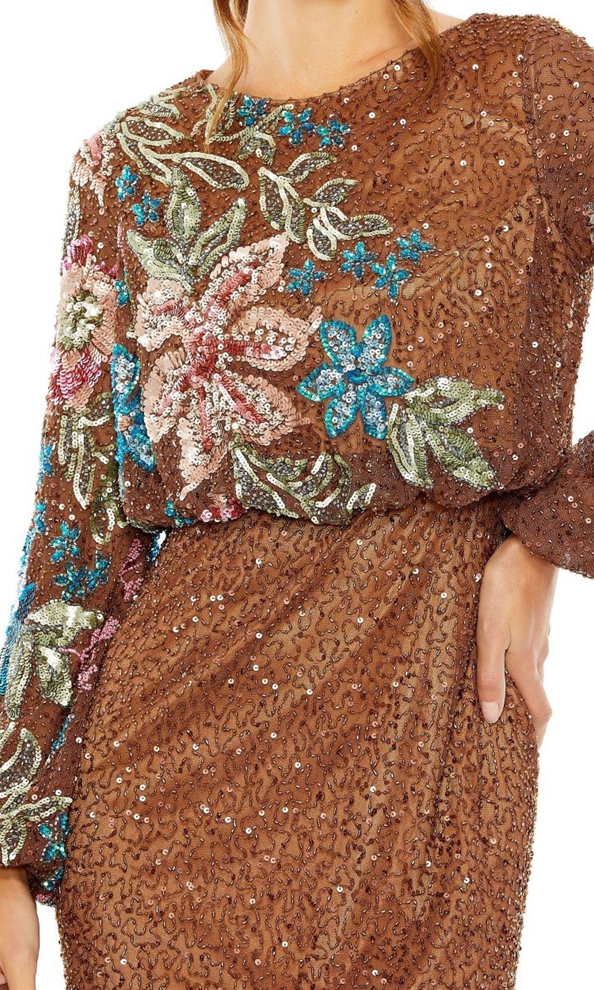 A person poses with one hand on their hip, wearing the Mac Duggal 5615 Beaded Long Sleeve Formal Dress featuring pink, blue, and green floral embroidery on the top and sleeves.