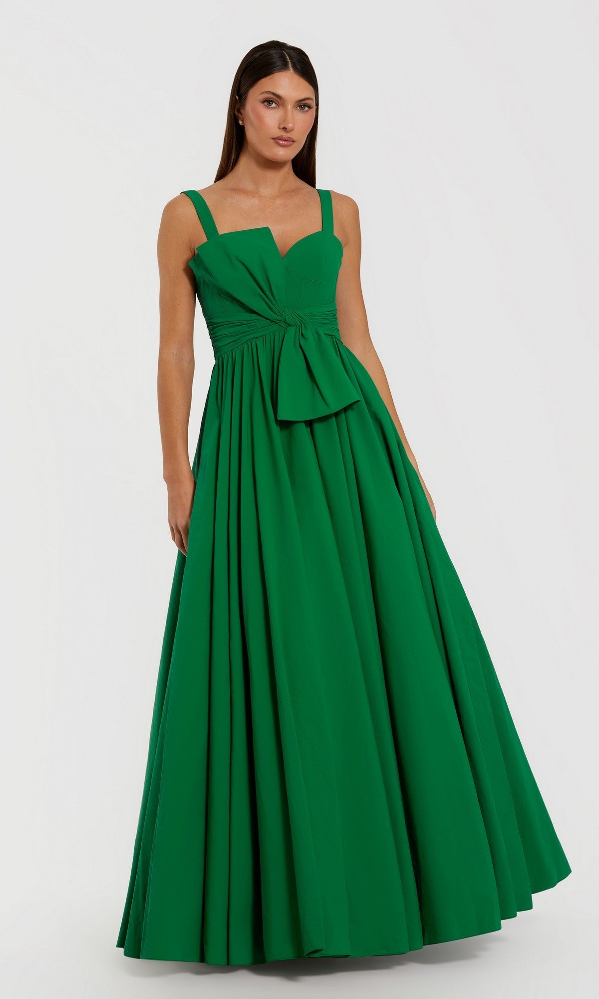 A woman stands against a plain white background wearing the Mac Duggal 56189 long formal dress in Spring Green—a sleeveless, floor-length ballgown crafted from elegant faille fabric, featuring wide straps, a fitted bodice, and a bow detail at the waist.