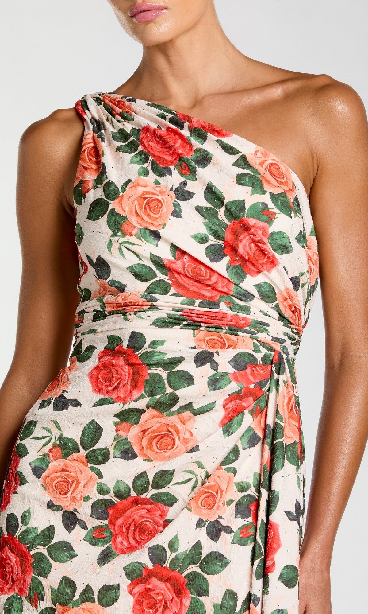 A woman wearing the Mac Duggal 56297 long formal dress, featuring a one-shoulder design and a red and orange rose print on a white background.