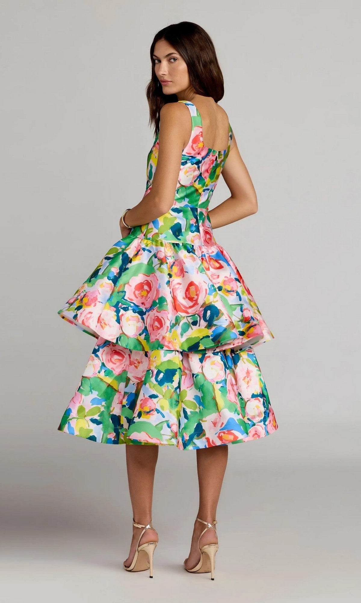 A woman stands in profile against a neutral background, wearing the Midi Party Dress: Mac Duggal 56414—a sleeveless printed mikado midi dress with a fitted bodice, flared ruffle A-line skirt, and square neckline—styled with nude heels.