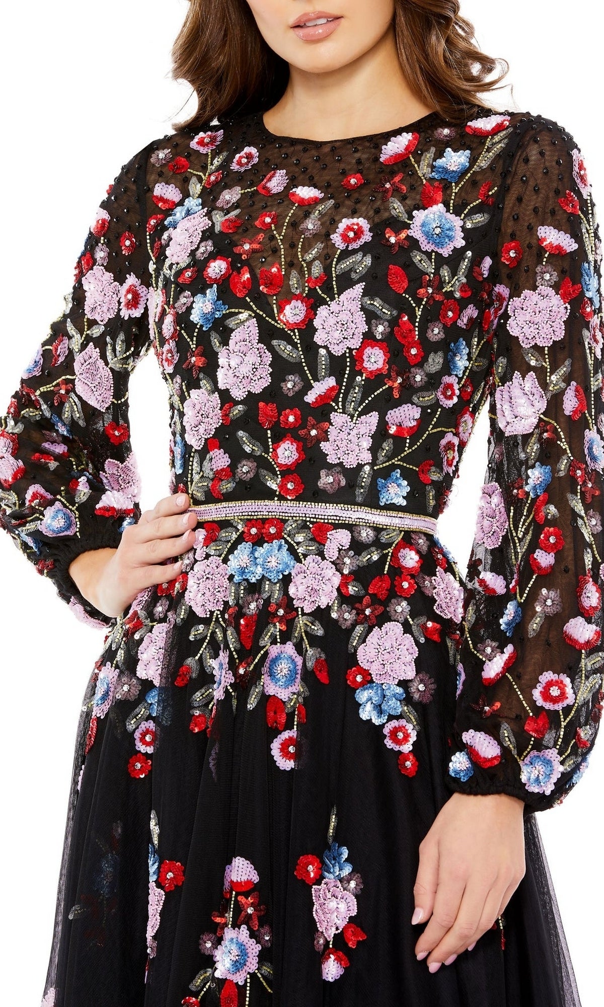 A woman wears the Mac Duggal Short Semi-Formal Dress 5712, a black long sleeve dress with red, purple, pink, and blue floral embroidery, delicate beading, and a beaded waist—ideal for semi-formal occasions.