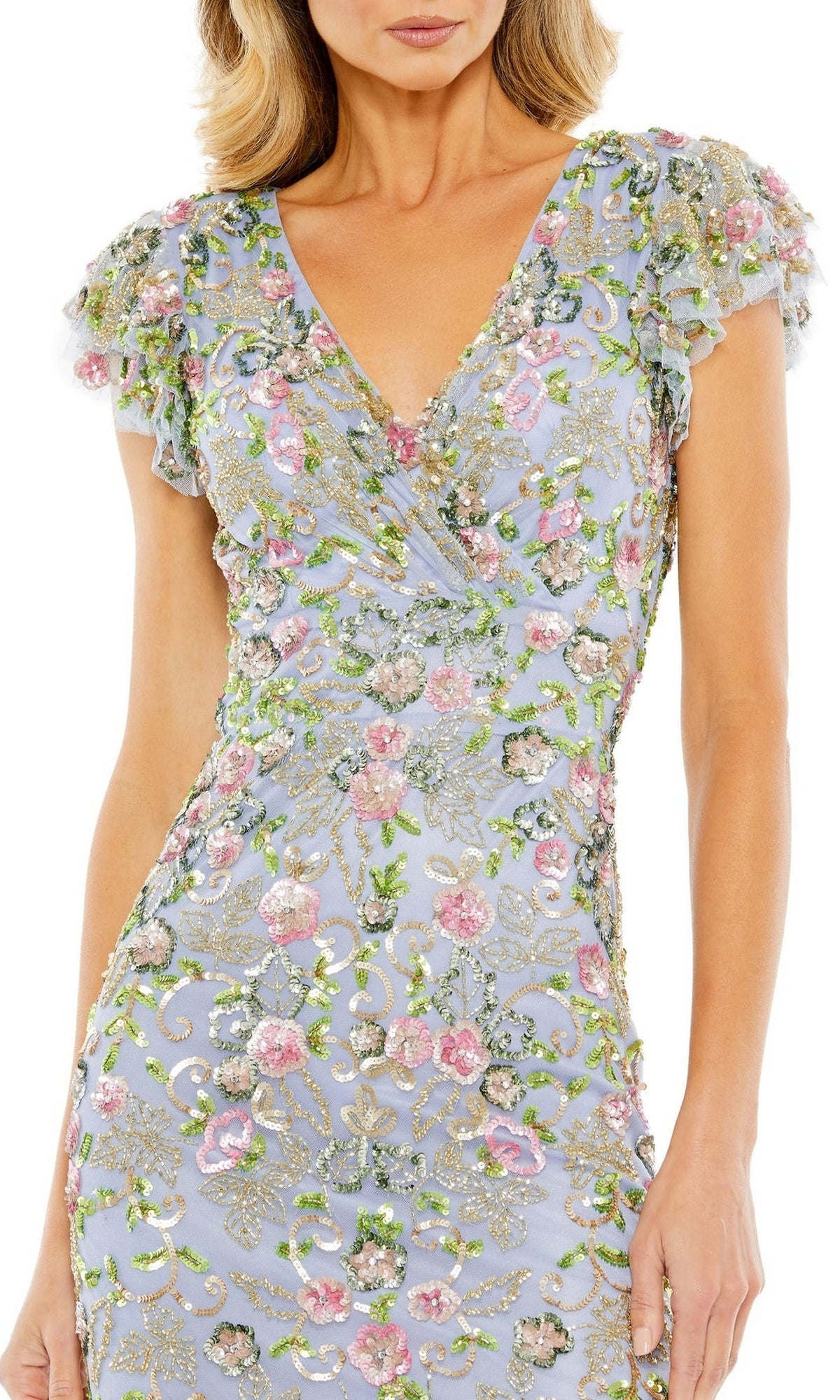 A woman wears the Mac Duggal 5722 Knee-Length Sequin Party Dress, featuring short sleeves, a V-neck, and pink, green, and gold floral embroidery with sequin details on light blue fabric.