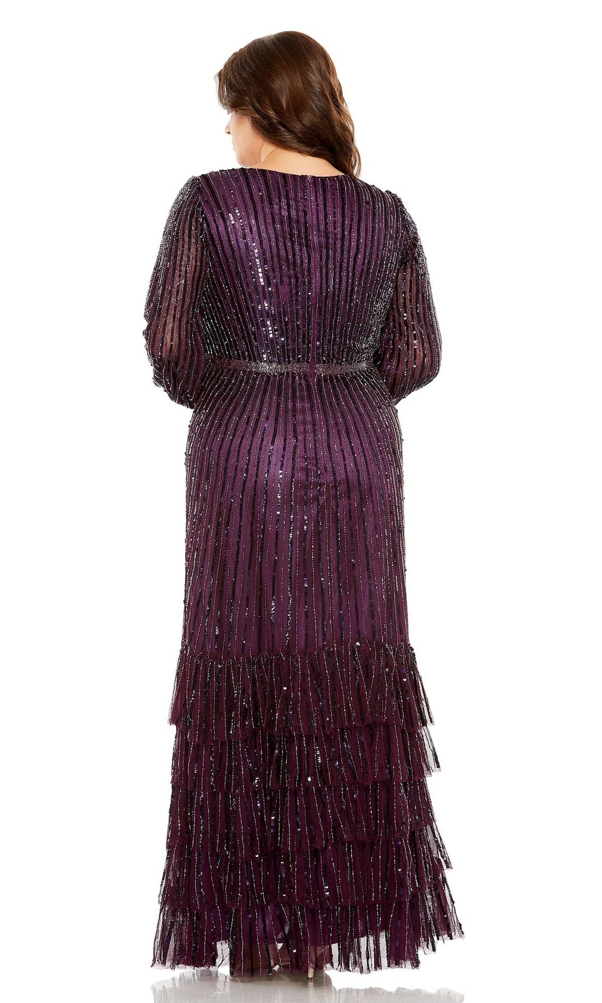 A woman faces away from the camera wearing the Long Plus-Size Formal Dress 5784 by Mac Duggal, featuring a purple hue, beaded details, vertical stripes, and tiered ruffles.