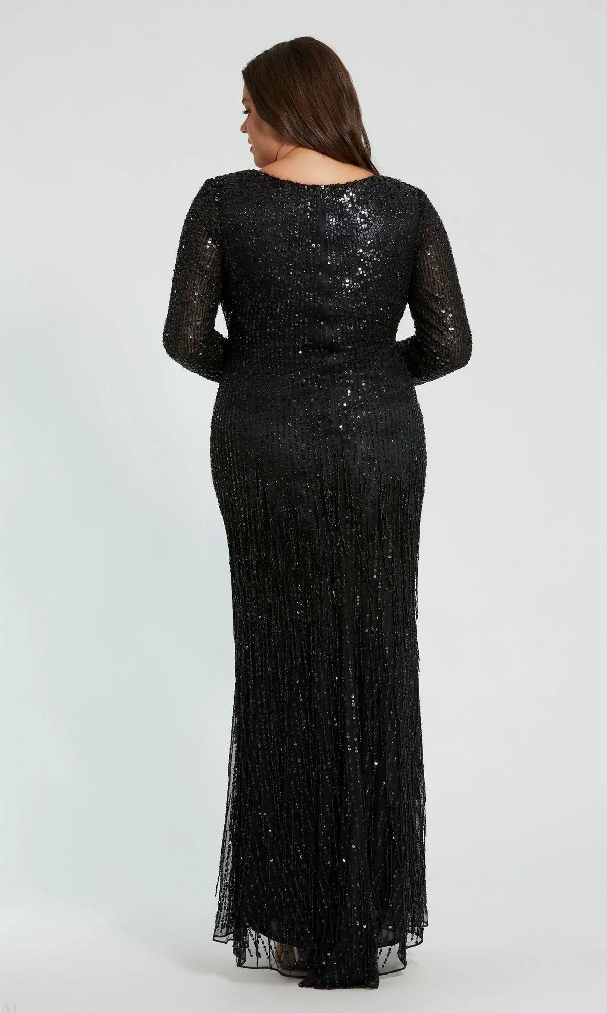 A woman with long brown hair is shown from the back against a plain light background wearing the Mac Duggal 5947, a black, floor-length plus-size formal dress with sequins and long sleeves.