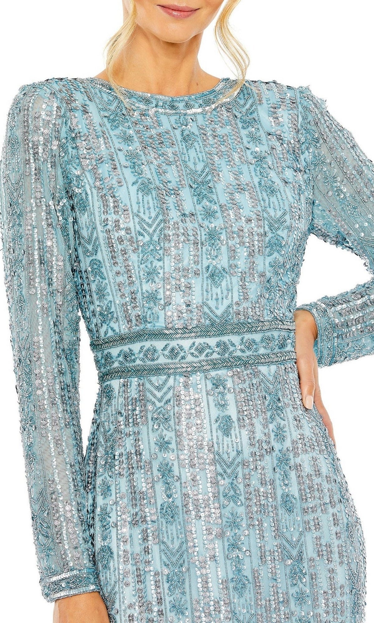 A woman in the Long Formal Dress 5981 by Mac Duggal, featuring light blue long sleeves with silver sequin patterns and beaded details, stands confidently with one hand on her hip.