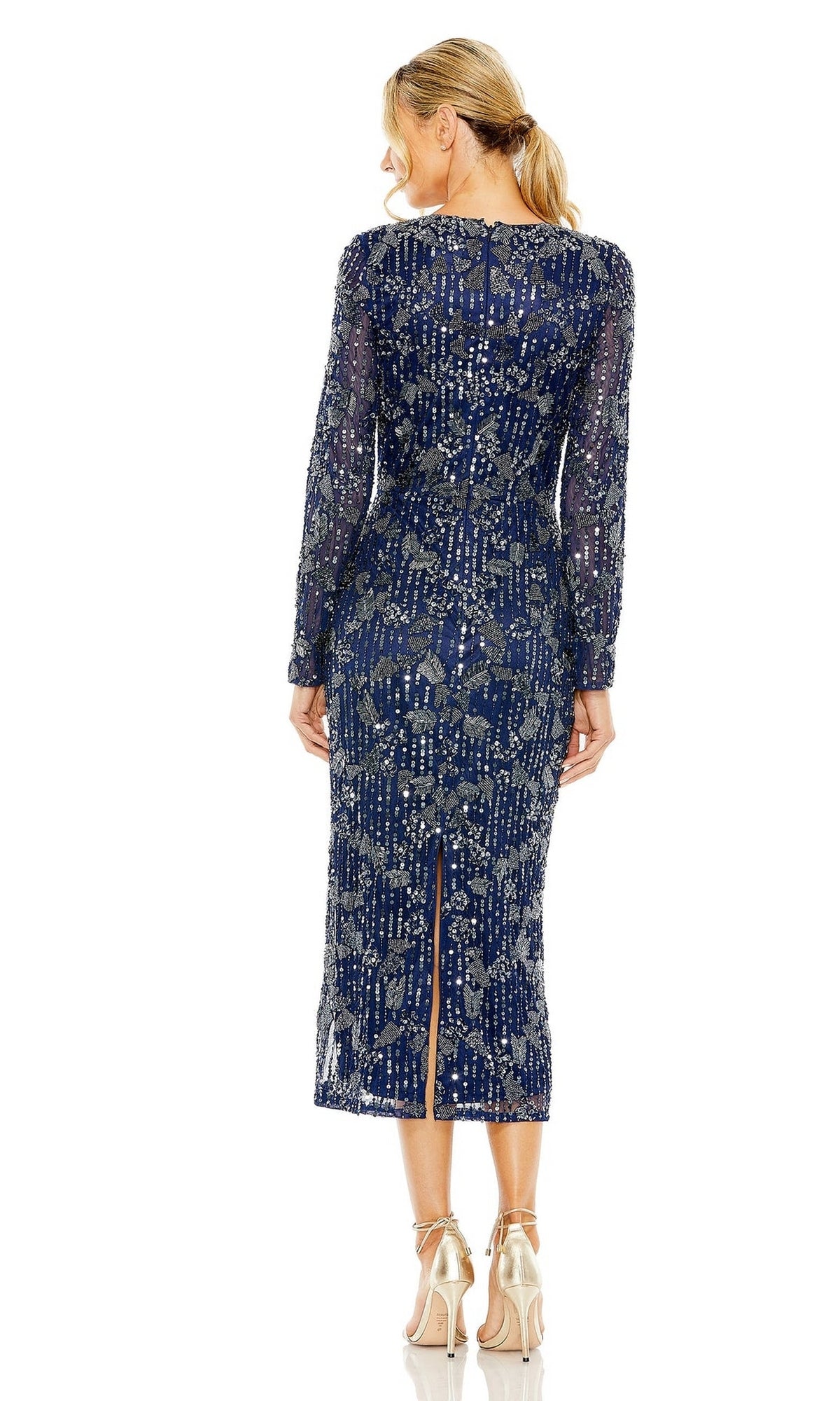 A woman stands facing away, wearing the Mac Duggal 5988 long sleeve navy blue beaded midi wedding guest dress with a back slit and nude high-heeled shoes.