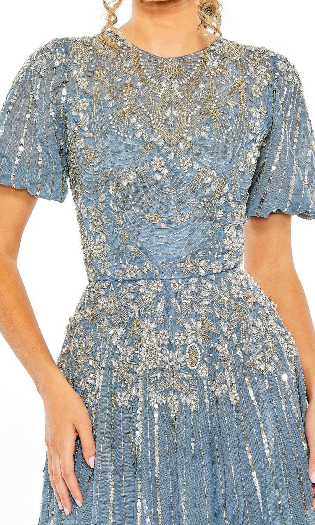 A woman wearing the Mac Duggal 5991 Short Sleeve Beaded Formal Dress in light blue, featuring intricate silver floral embroidery and bead detailing on the bodice, sleeves, and skirt.