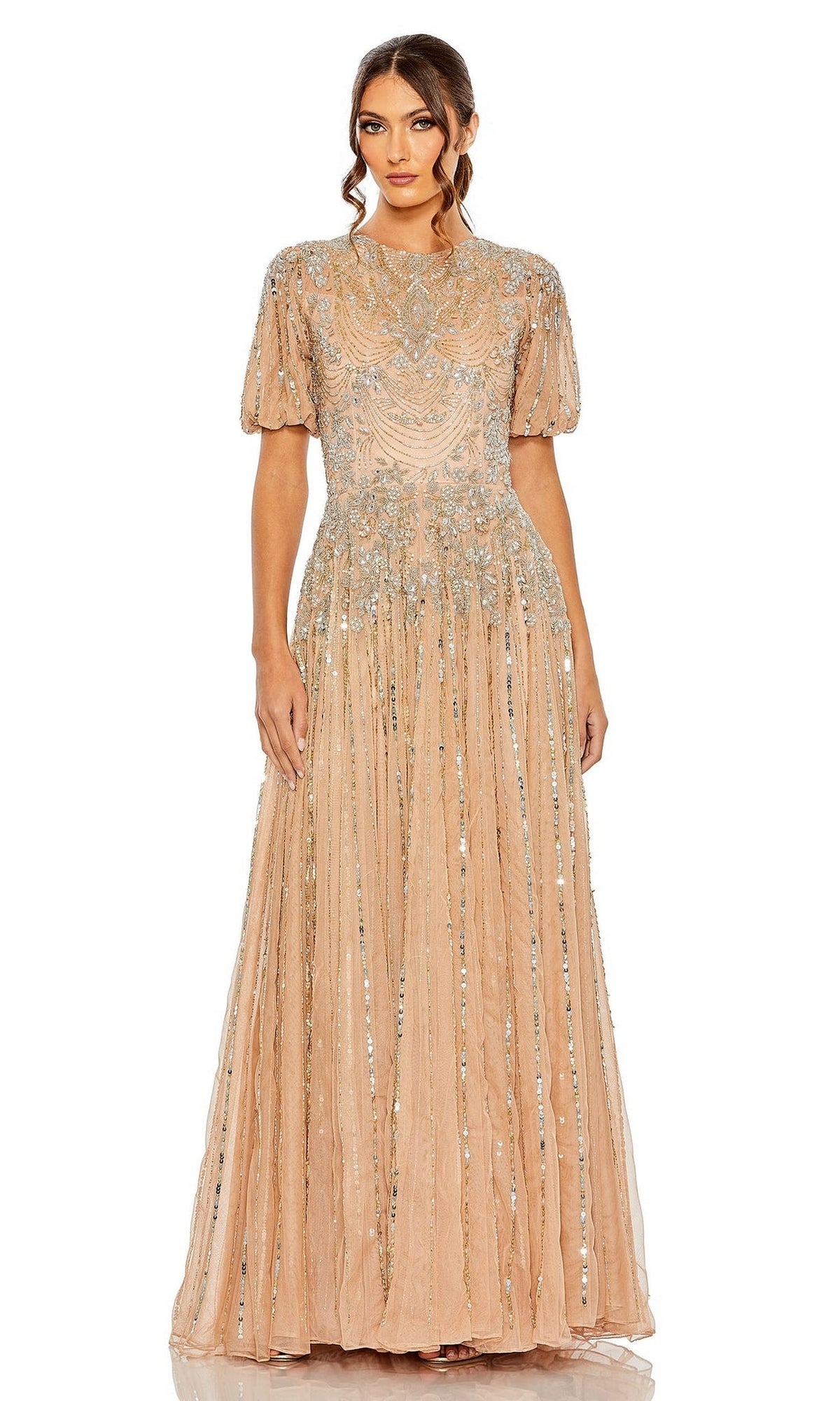 A woman wears the Mac Duggal 5991 Short Sleeve Beaded Formal Dress, a floor-length evening gown adorned with silver sequin embellishments, and looks directly at the camera.