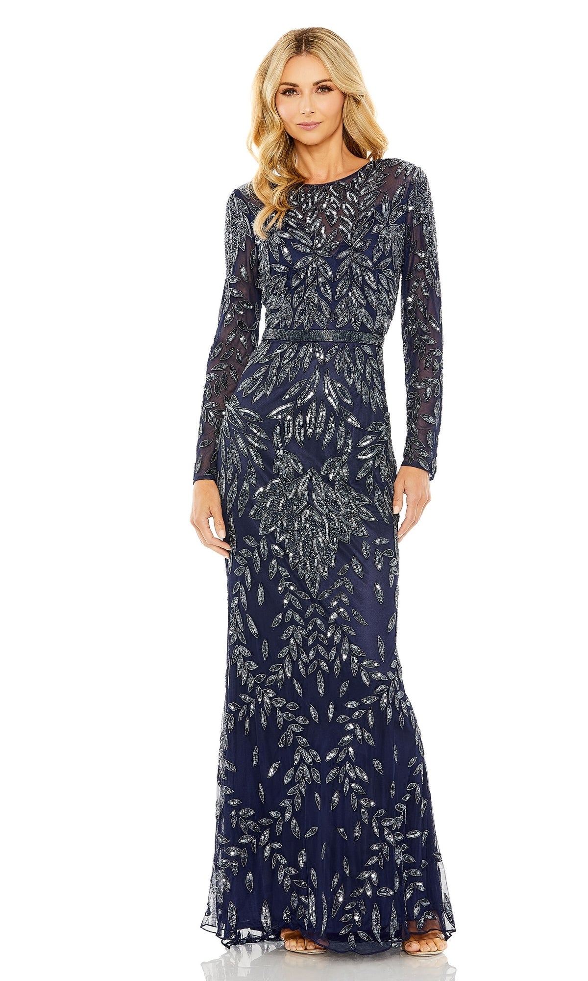 A woman faces forward in the Mac Duggal 6023— a long blue beaded formal dress featuring elegant silver leaf-pattern embellishments and long sleeves.