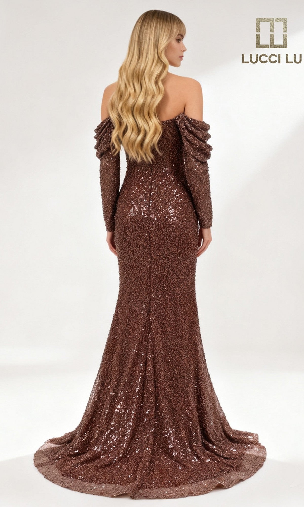 A woman with long wavy blonde hair wears the off-shoulder, floor-length brown Lucci Lu 6060 formal dress adorned with sparkling sequins, standing with her back to the camera. The Lucci Lu logo appears in the corner.