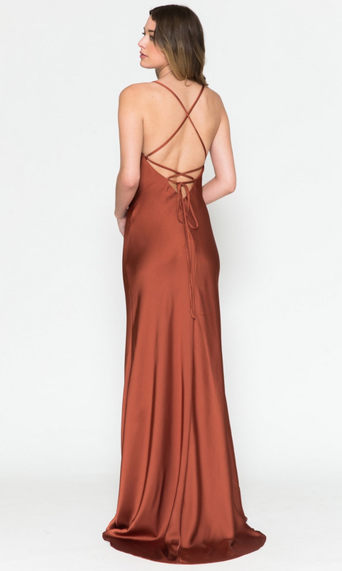 A woman wears the Cowl-Neck Sleek Long Satin Prom Dress 6111, featuring thin straps and a crisscross open back, standing against a plain white background.