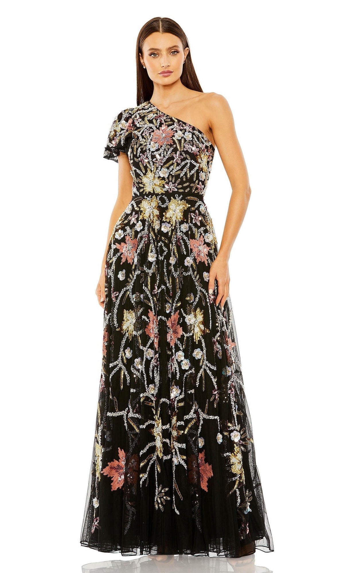 A woman stands wearing the Long Formal Dress 6134 by Mac Duggal, a black, floor-length, one-shoulder formal gown adorned with colorful floral embroidery.