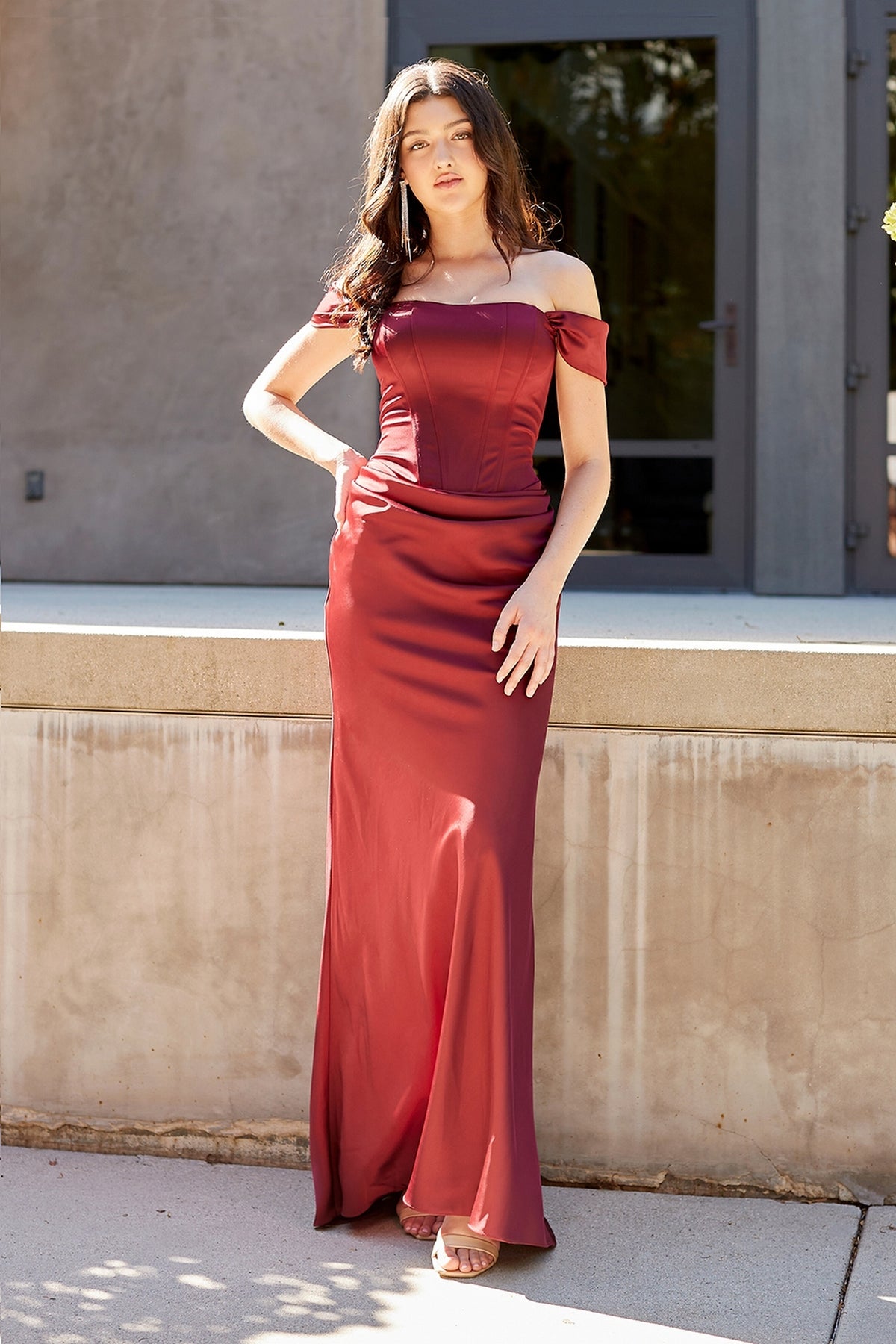 Woman wearing a wine-colored Amelia Couture 6151 floor-length off-the-shoulder prom dress with a corset-style bodice.
