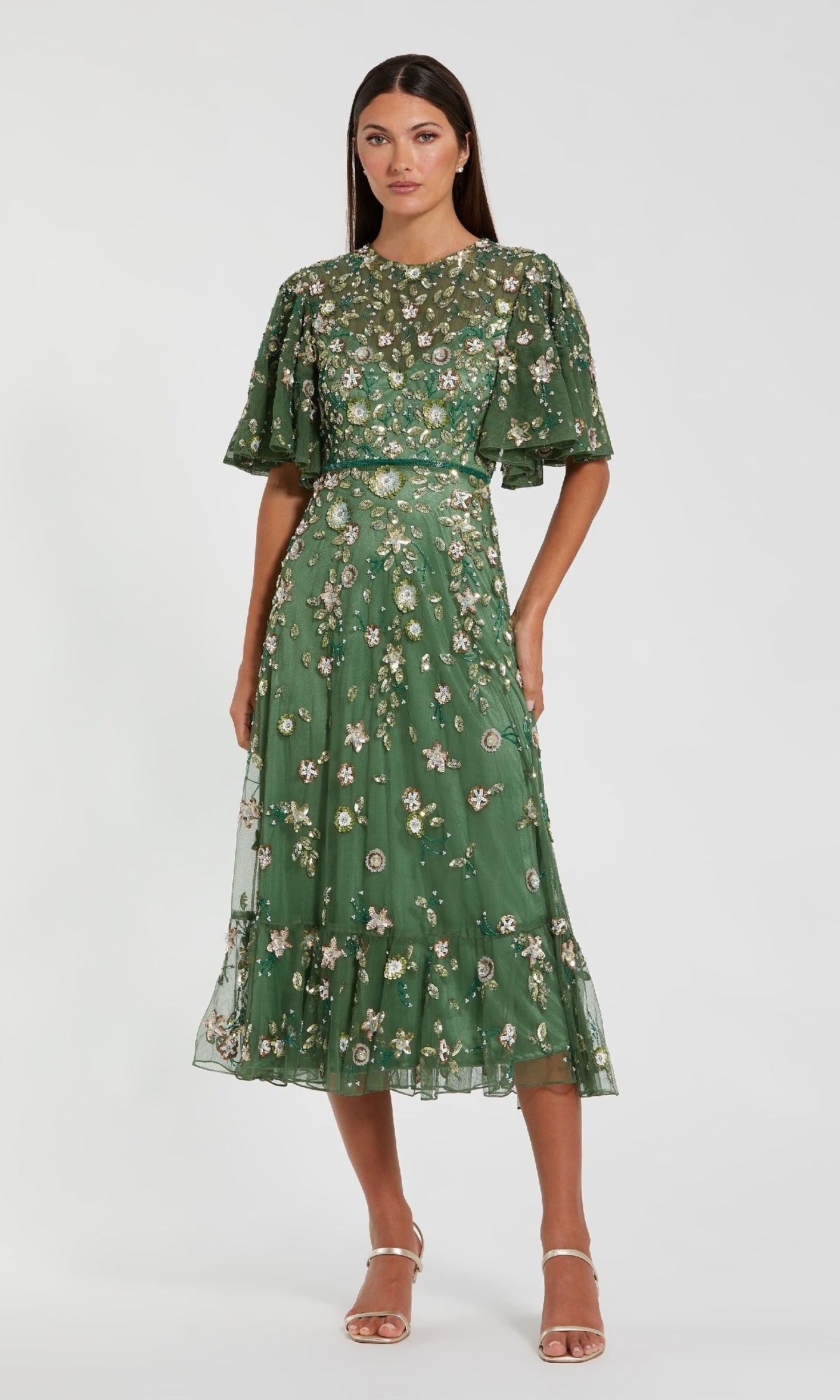 Woman wearing a green floral dress on a white background