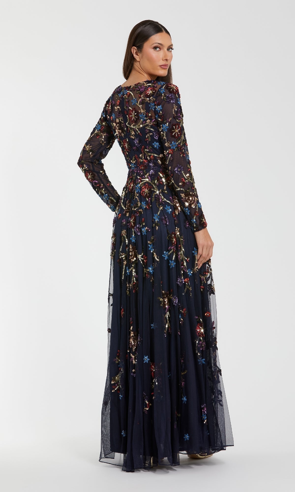 Woman wearing a long, dark floral dress on a white background