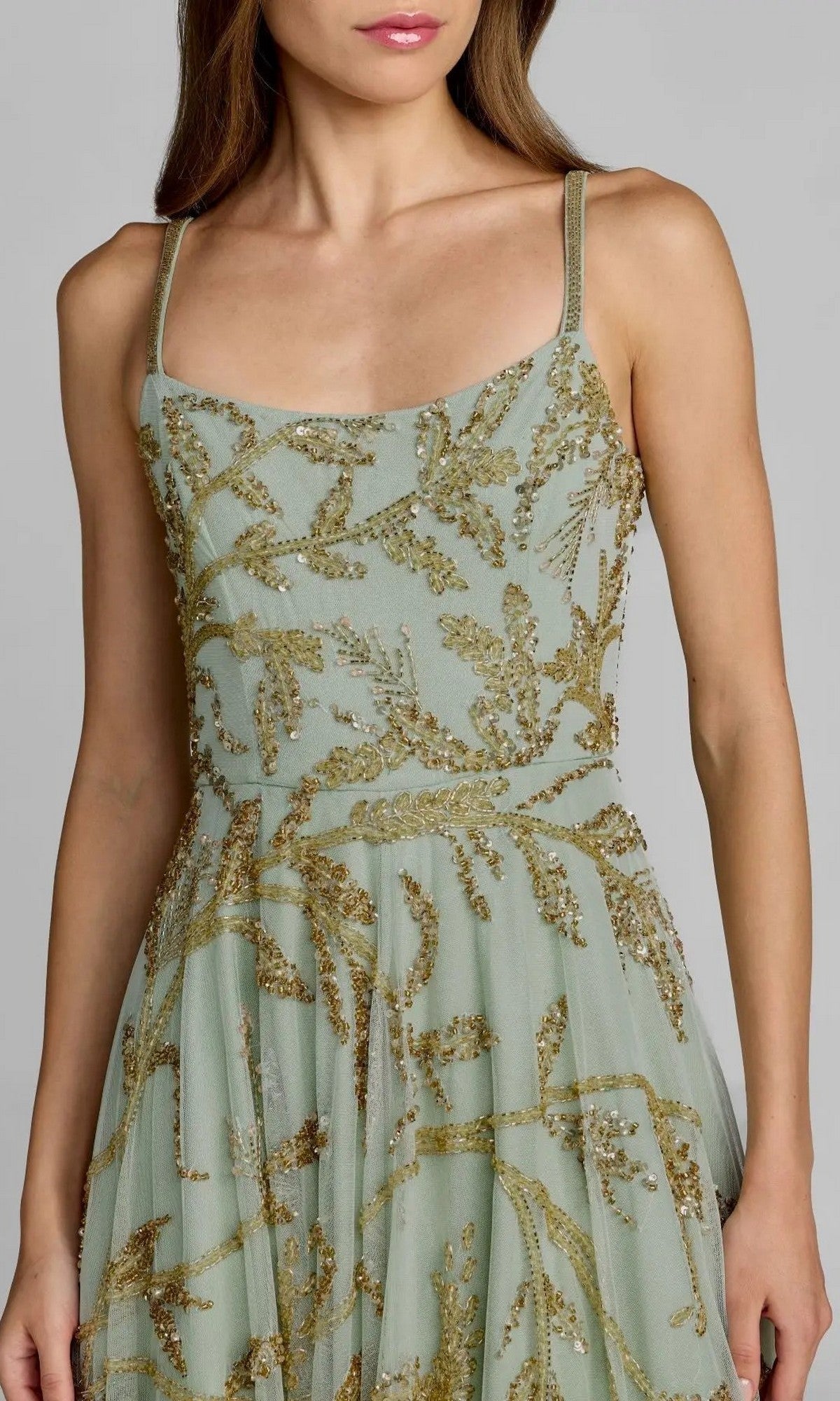 A woman wearing the Tea-Length Party Dress—Mac Duggal 6255—featuring thin straps, a sleeveless silhouette, and intricate gold sequin embroidery on light green fabric. Only her upper body is visible, showcasing a stunning blend of elegance and sparkle.