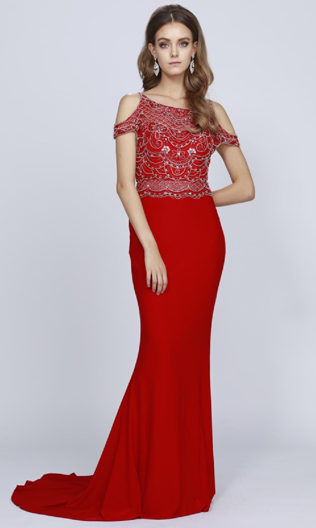 A woman models the Juliet 660 long prom dress, featuring a form-fitting silhouette, beaded bodice, and cold shoulder sleeves against a plain background.