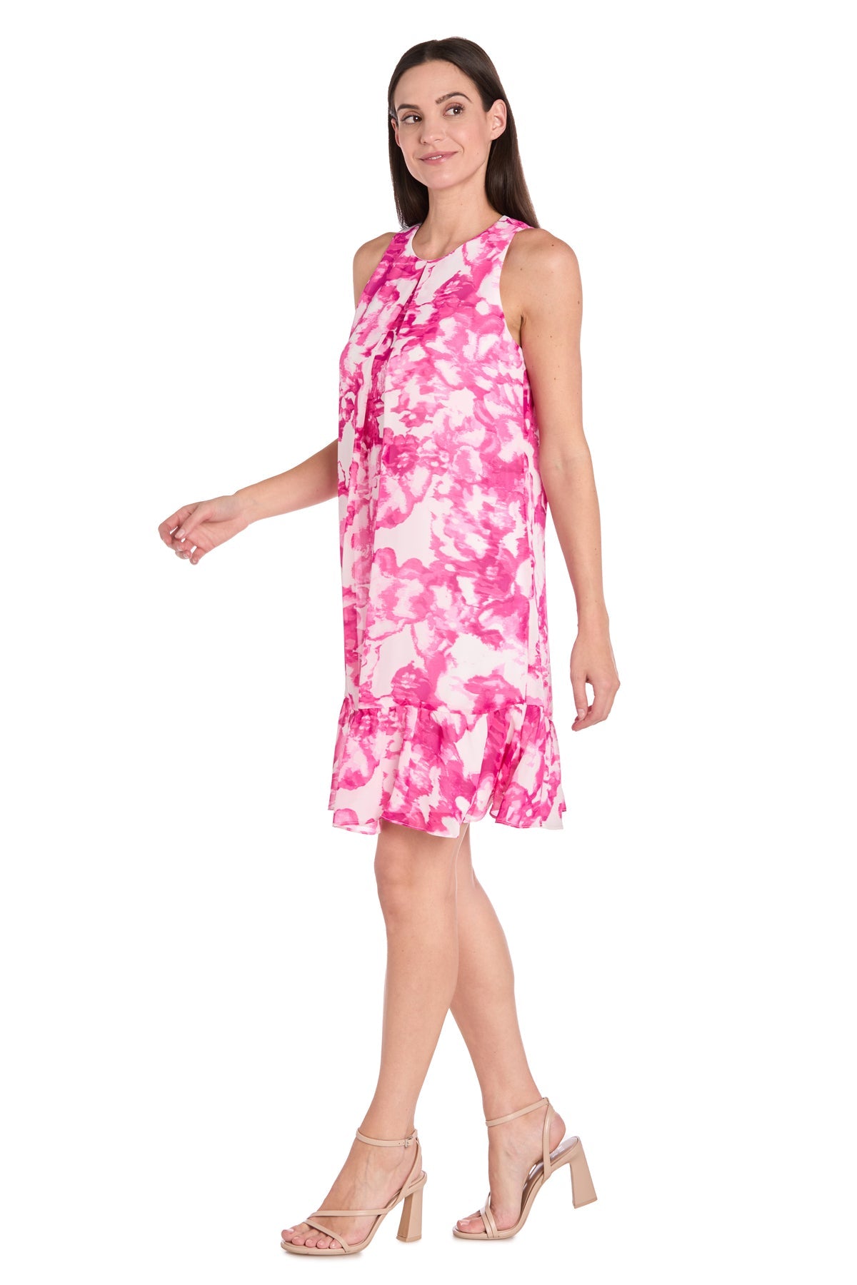 A woman models the R&M Richard 6655P—a petite knee-length party dress with pink and white floral print, sleeveless design, ruffle hem—paired with nude heels against a white background; perfect for any occasion.