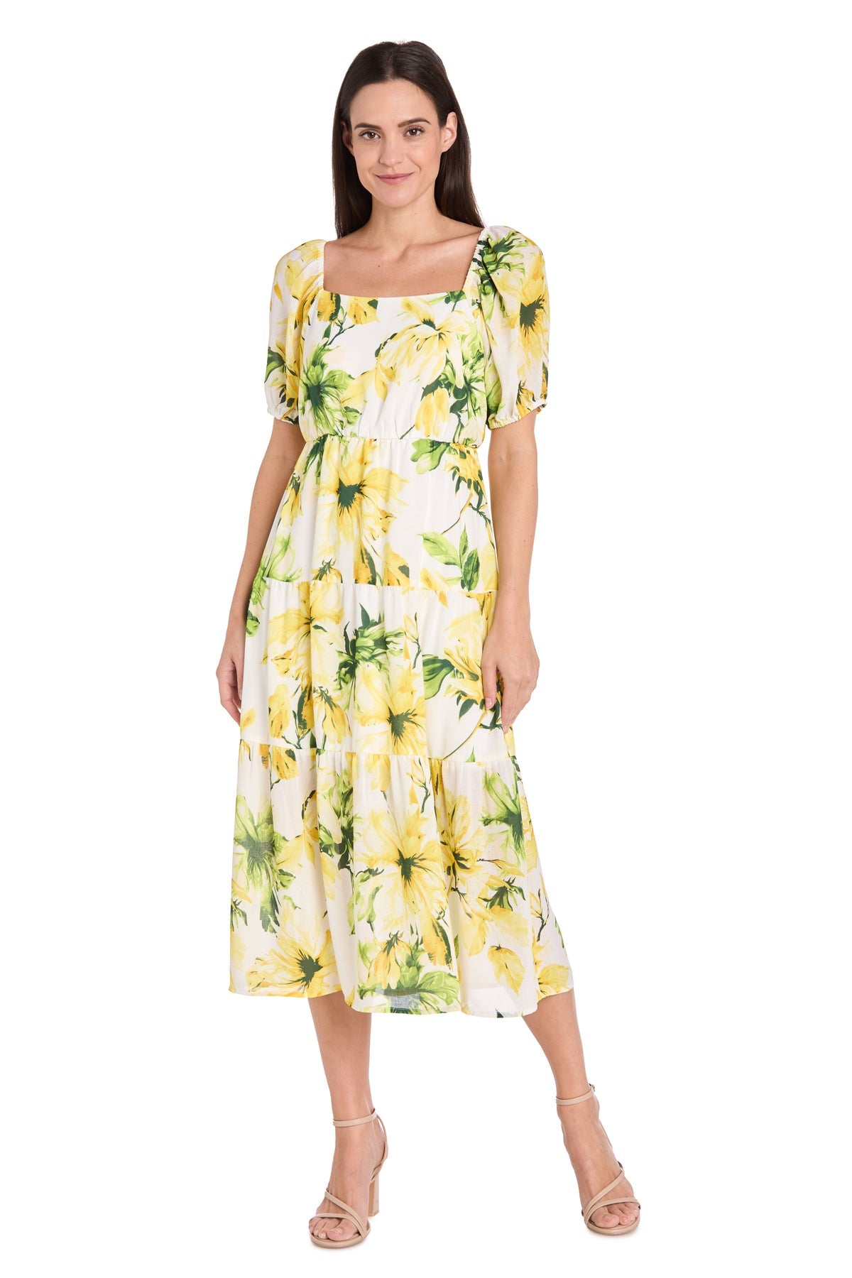 A woman wears the Petite Midi Yellow Print Party Dress: R&M 6672P with short puff sleeves and a square neckline, paired with beige heeled sandals, standing against a plain background.