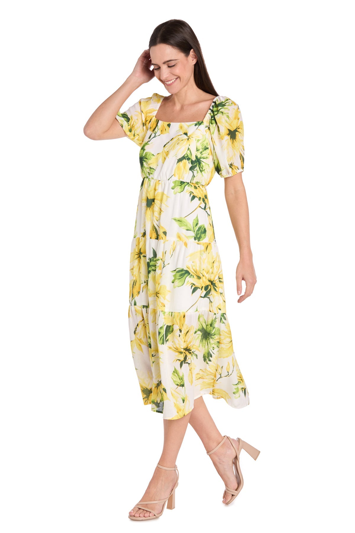 A woman smiles while standing in the Petite Midi Yellow Print Party Dress: R&M 6672P with puff sleeves and beige high-heeled sandals.