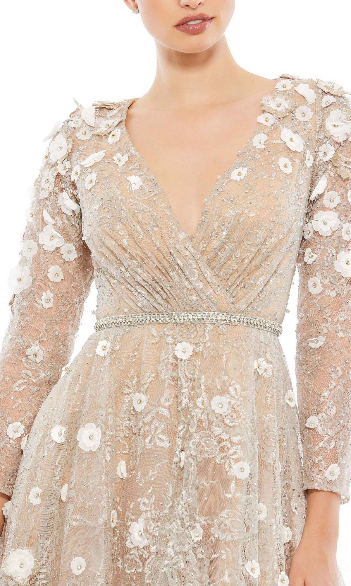 A woman wearing the Mac Duggal Short Wedding Guest Dress 67387, featuring sheer long sleeves, white floral appliqués, and a beaded waist belt.