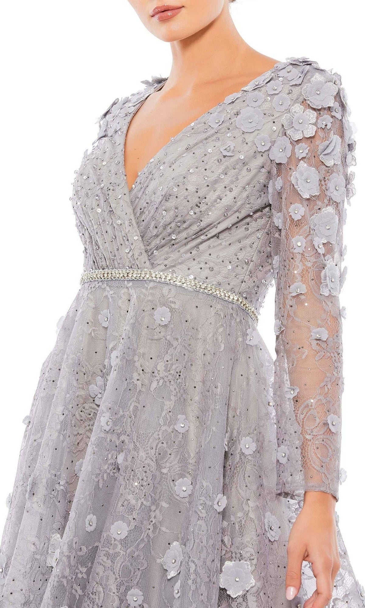 A woman wearing the Mac Duggal Short Wedding Guest Dress 67387, a light gray long-sleeve dress with floral appliqués, bead embellishments, a V-neckline, and a decorative waistband.