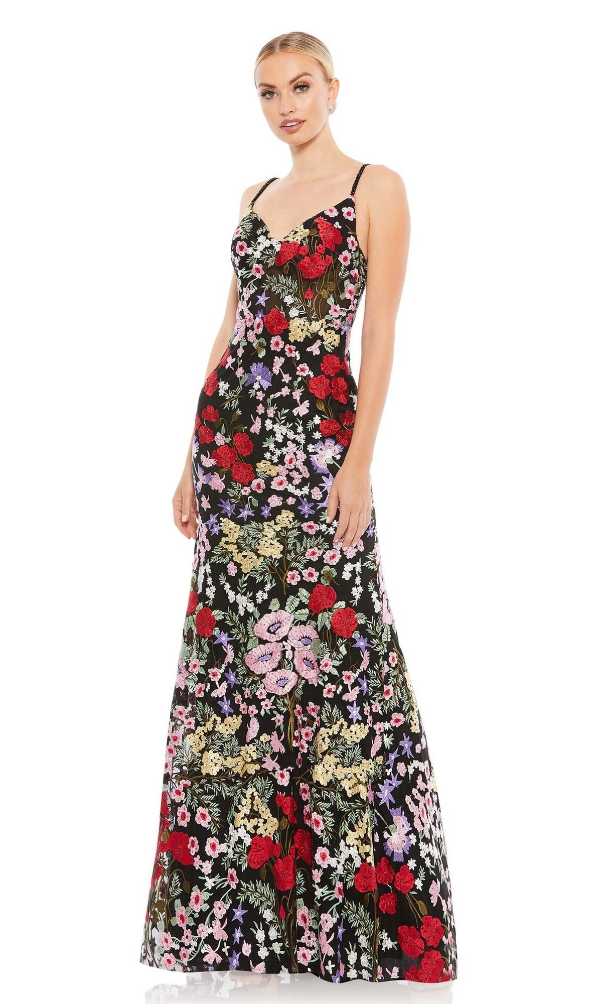 A woman models the Mac Duggal 67473 long formal dress, featuring colorful floral patterns, against a plain white background.