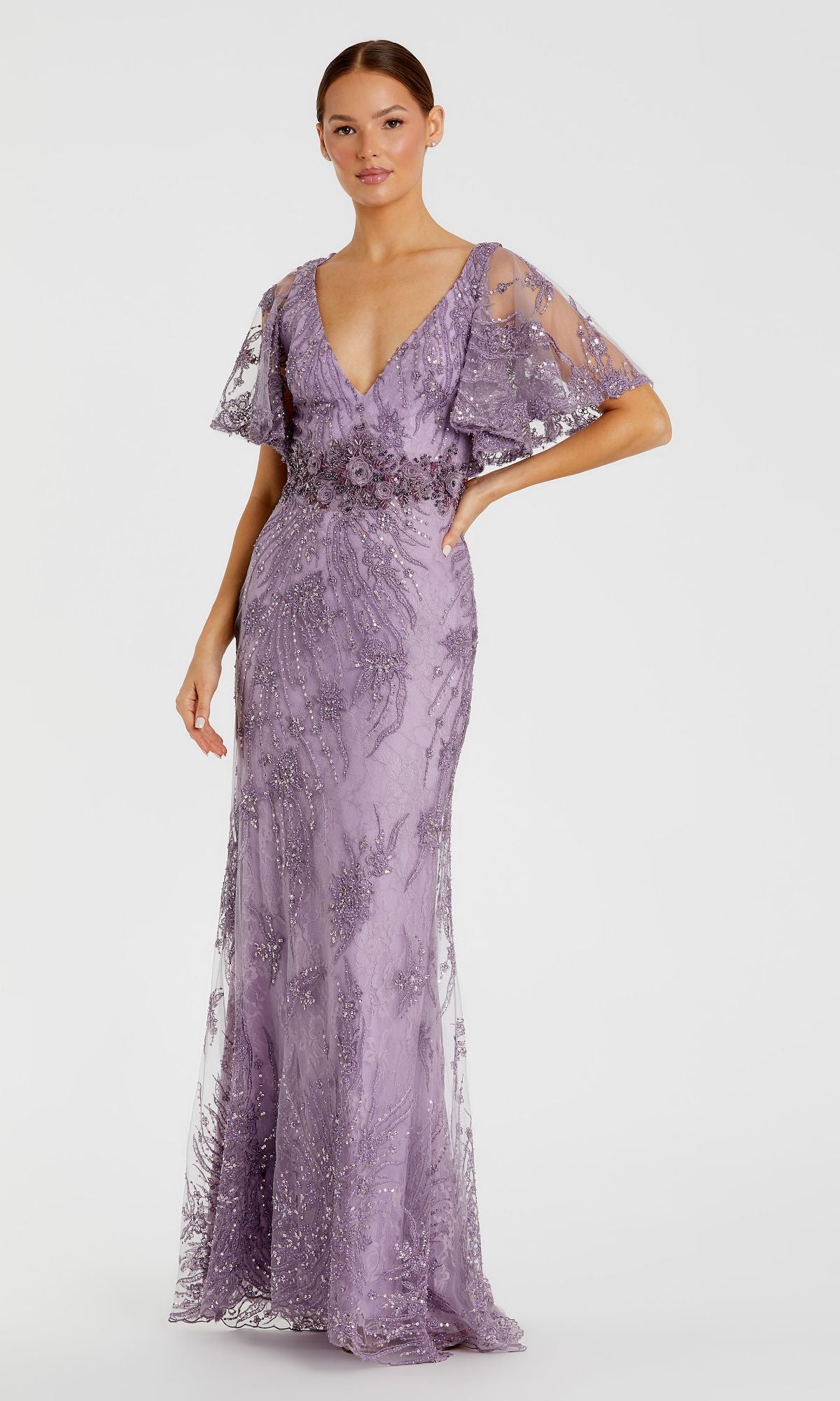 A woman poses in the Long Formal Dress 67493 by Mac Duggal, a floor-length lavender gown featuring a deep V-neck, short flutter sleeves, and intricate bead and sequin embellishments.