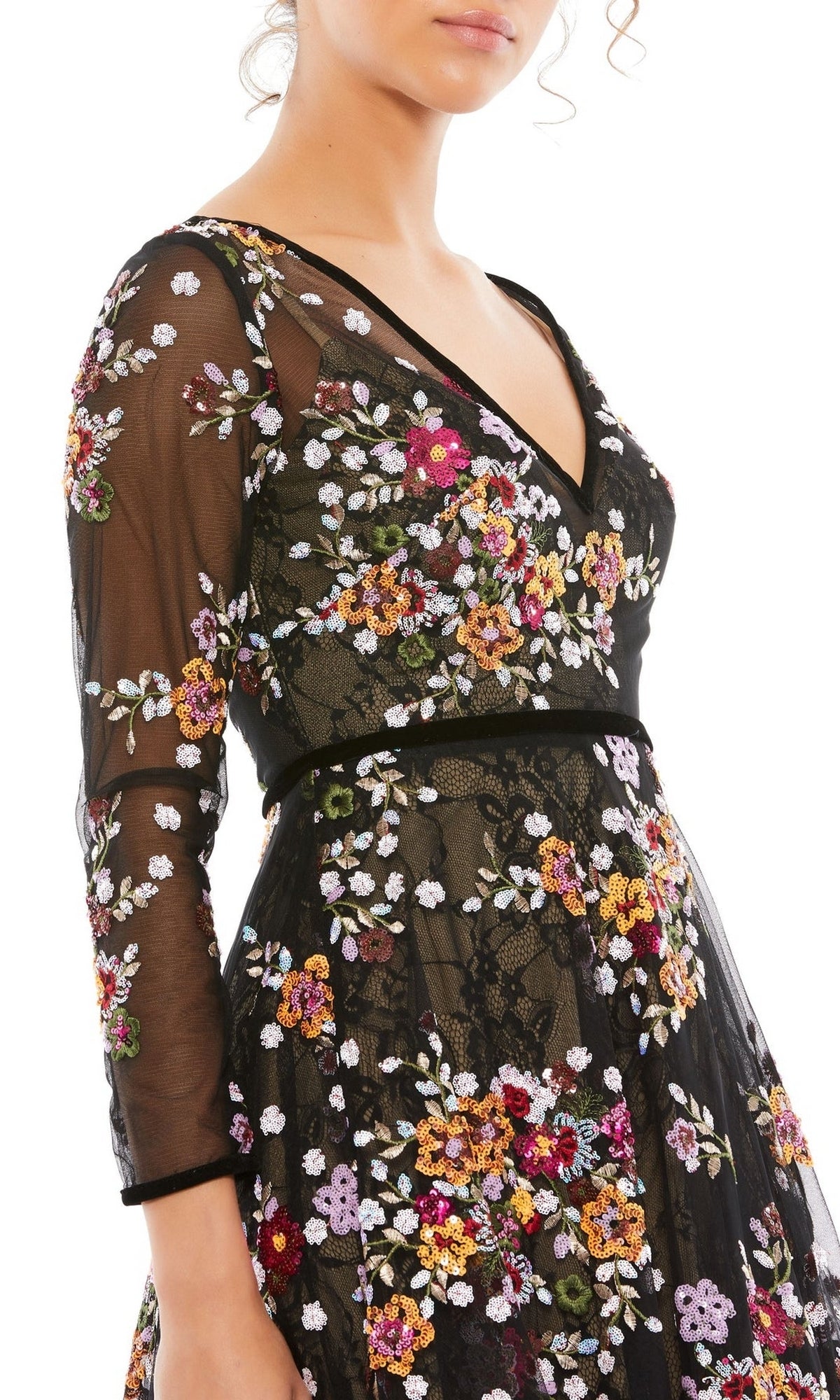 A woman wears the Mac Duggal 67499 Print Midi Wedding-Guest Dress, featuring sheer sleeves and colorful floral embroidery—shown from shoulders to mid-thigh, facing left—a stunning choice for any special occasion.