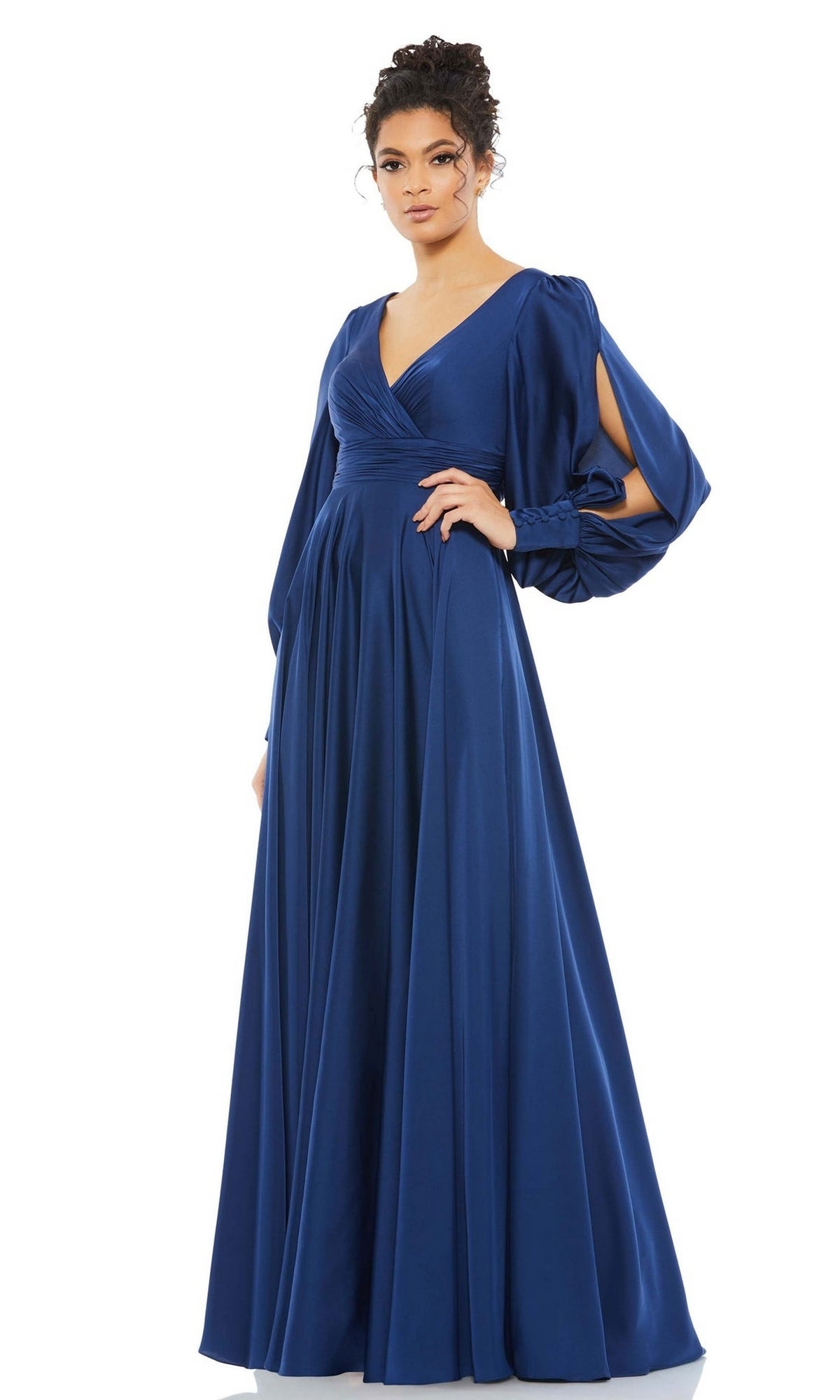 A woman wears the Long Formal Dress 67847 by Mac Duggal, a royal blue, floor-length formal gown featuring a V-neck and long, draped split sleeves for an elegant look.