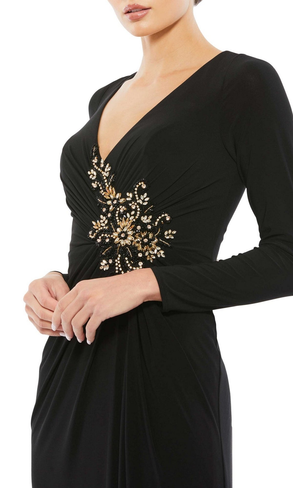 Woman wearing the Mac Duggal 67848 long sleeve long formal dress, featuring a deep V neckline and gold floral embellishments at the waist, shown from mid-thigh up.