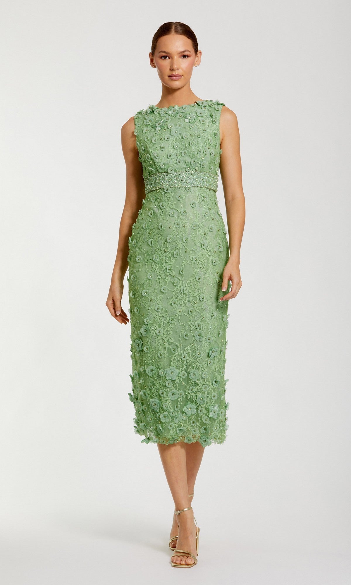A woman wears the Mac Duggal 67853 knee-length party dress in light green lace with floral detailing and open-toe heels, standing against a plain background.
