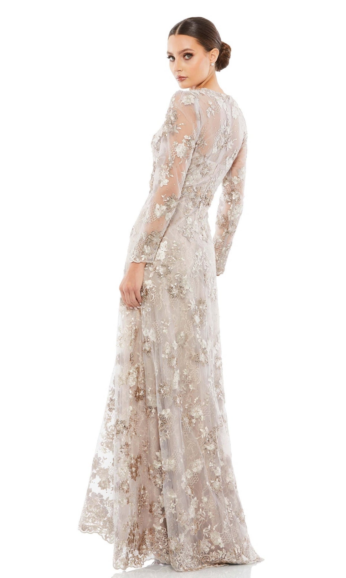 A woman models the Mac Duggal 67875 Long Mocha Lace Formal Dress, a floor-length, long-sleeved gown with sheer lace and floral embroidery, posing over her shoulder against a plain white backdrop.