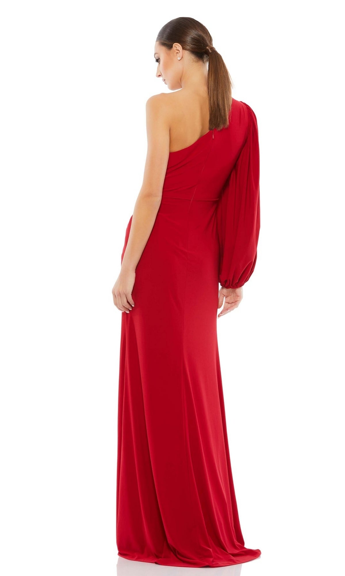 A woman faces away against a white background, wearing the Mac Duggal 67879 asymmetrical long formal dress in red with a single sleeve.