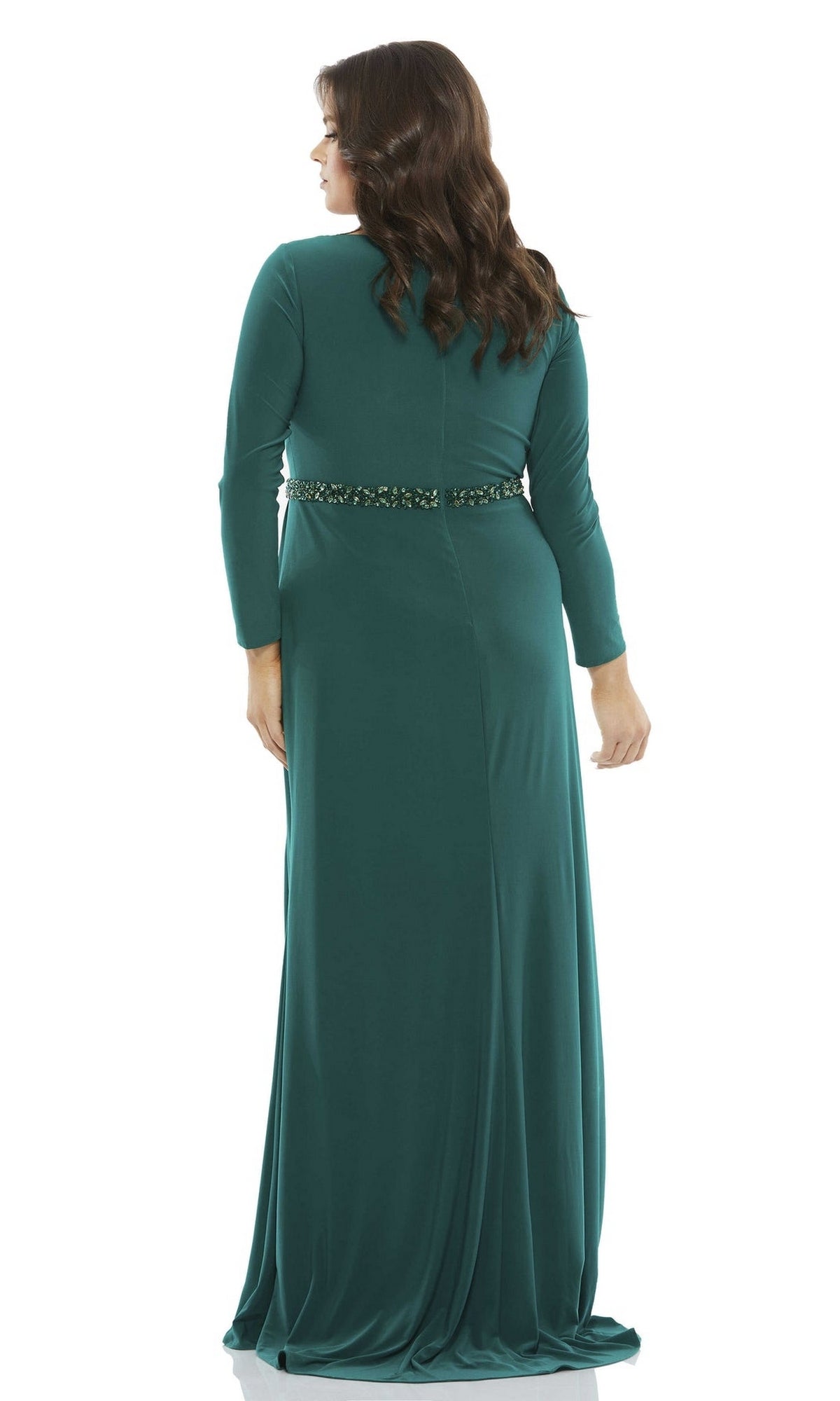 A woman is shown from the back wearing the Long Plus-Size Prom Dress 67899 by Mac Duggal, a green, floor-length gown with long sleeves, waist embellishments, and a v-neckline, set against a white background.