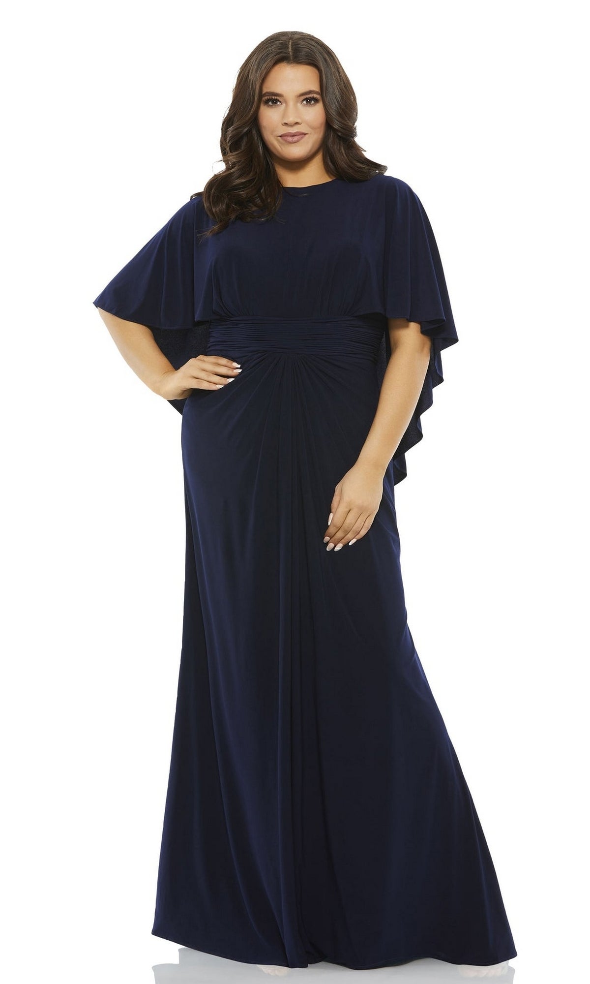 A woman is seen wearing the Long Plus-Size Prom Dress 67929 by Mac Duggal, a floor-length navy gown with cape sleeves and gathered waist detailing, set against a plain white background.