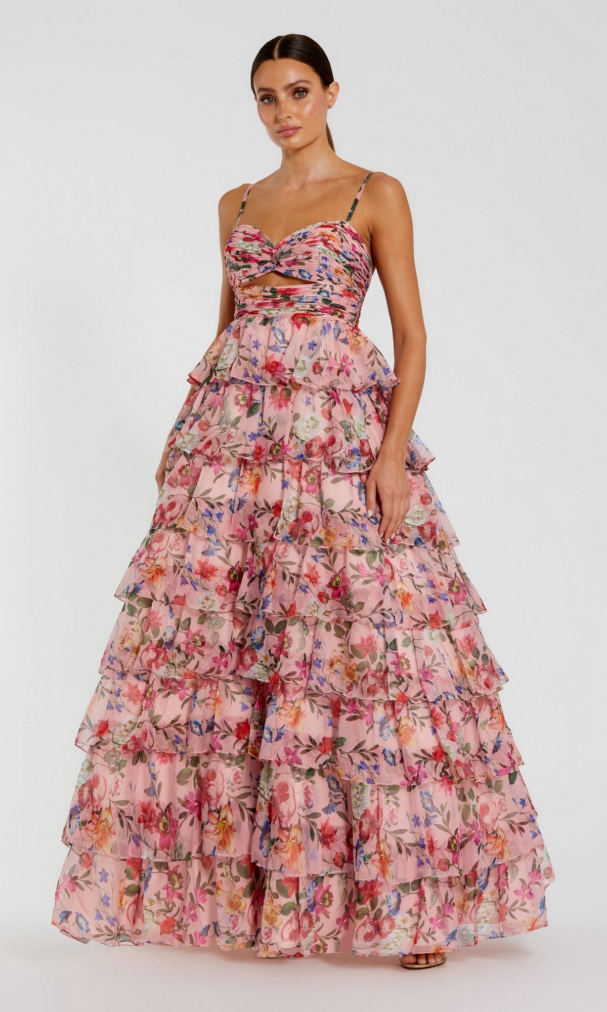 A woman models the Mac Duggal 67966 Violet Print Prom Ball Gown—a tiered, ruffled floral dress with thin straps—against a plain white background.